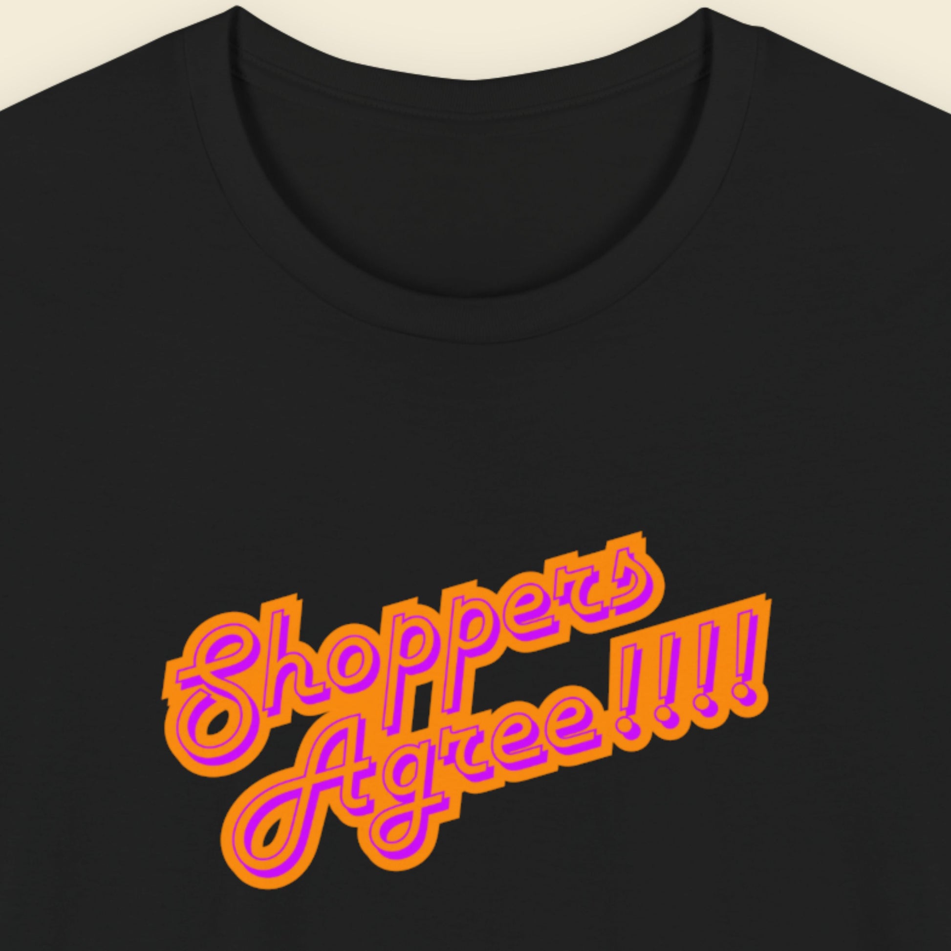 Black t-shirt with humorous colorful text on a beige background.