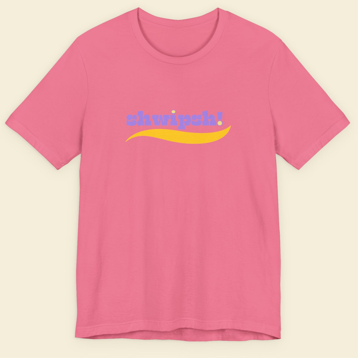 Pink t-shirt with multicolored 'shwipsh!' text on a beige background.