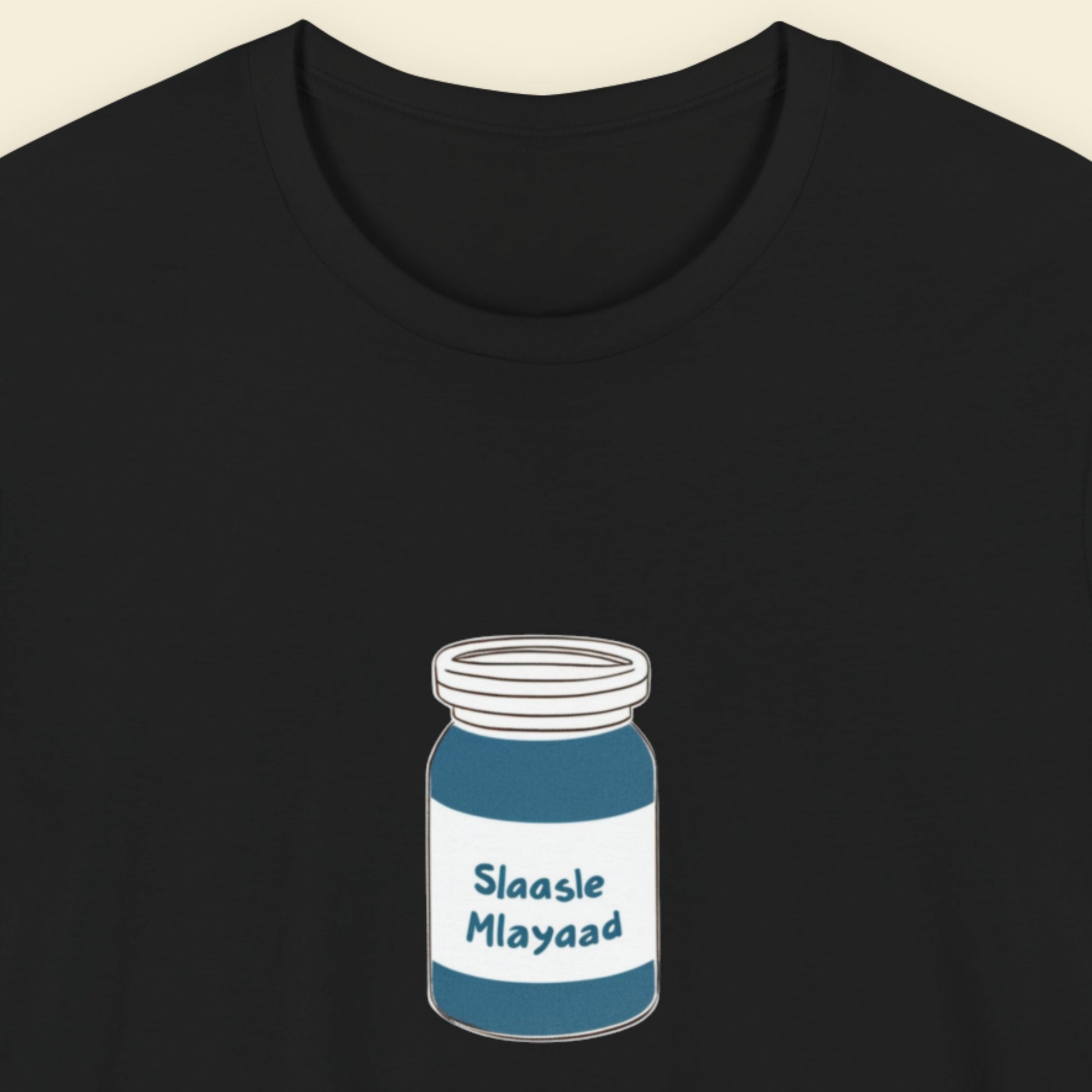 Black t-shirt with a drawing of a jar of Slaasle Mlayaad on a beige background.