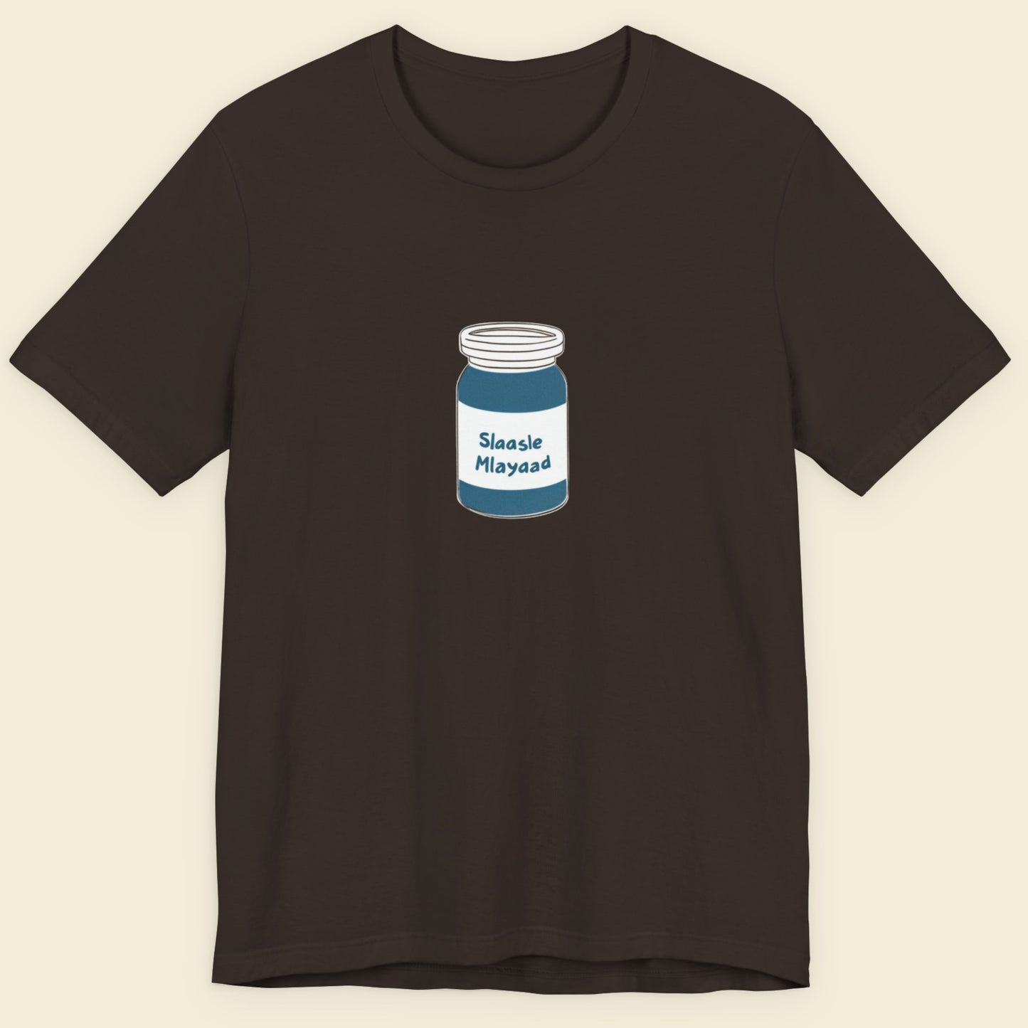 Brown t-shirt with a drawing of a jar of Slaasle Mlayaad on a beige background.