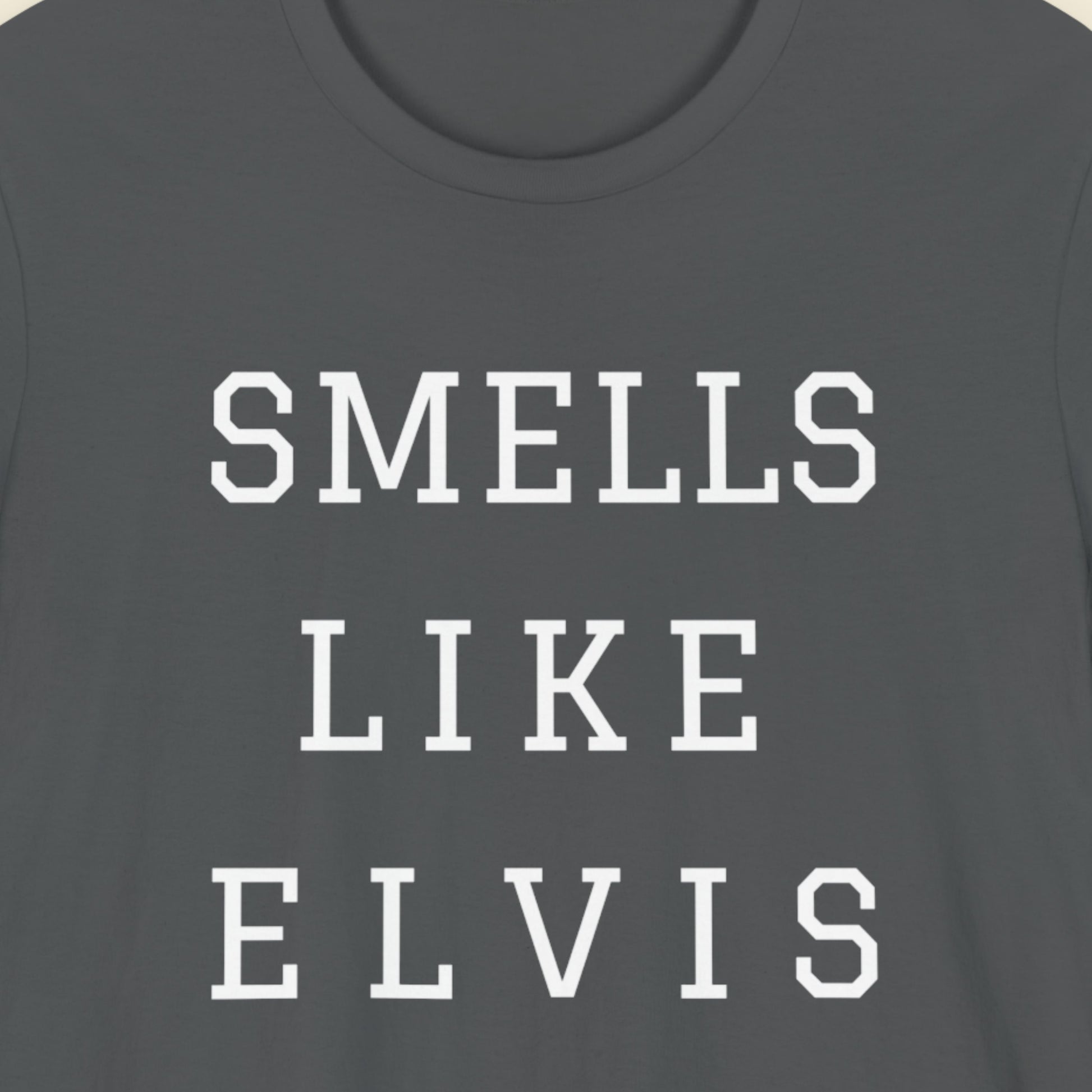 Gray t-shirt with 'SMELLS LIKE ELVIS' text in white on a plain background.