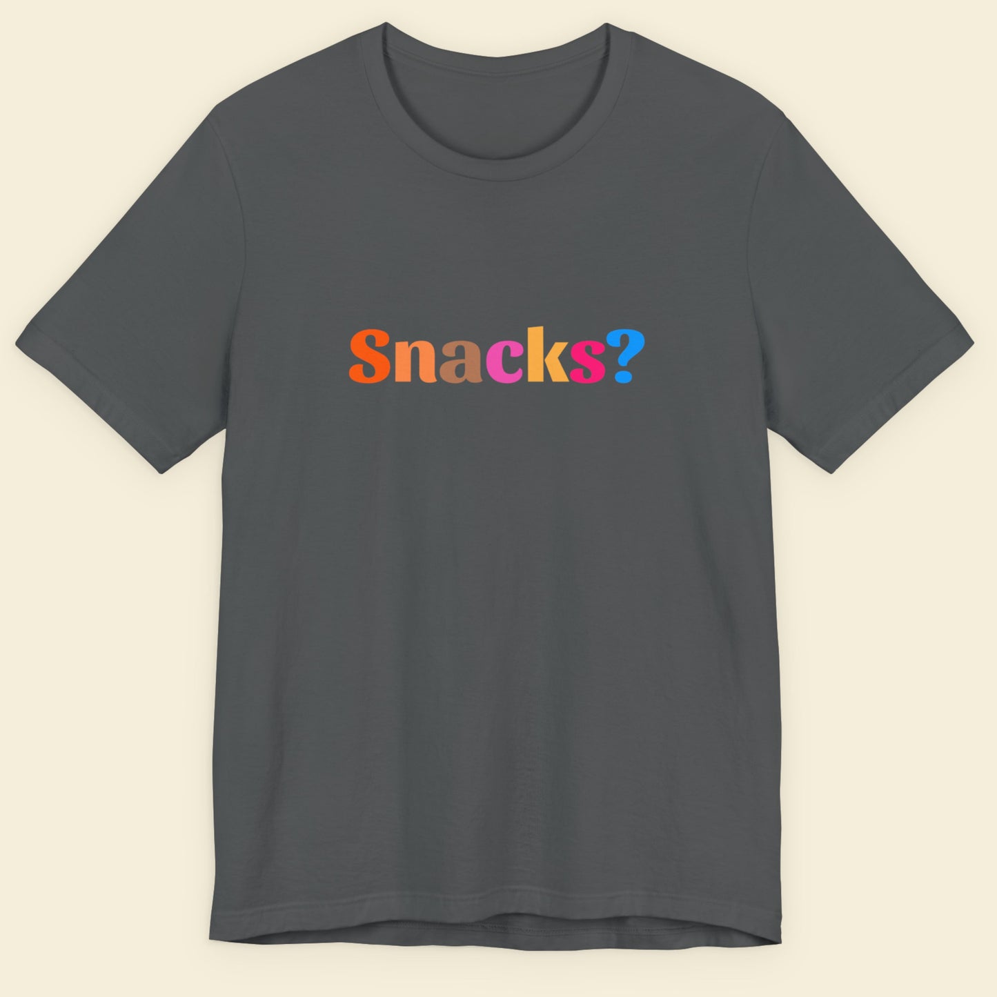 Gray t-shirt with 'Snacks?' text in multicolor on a beige background.