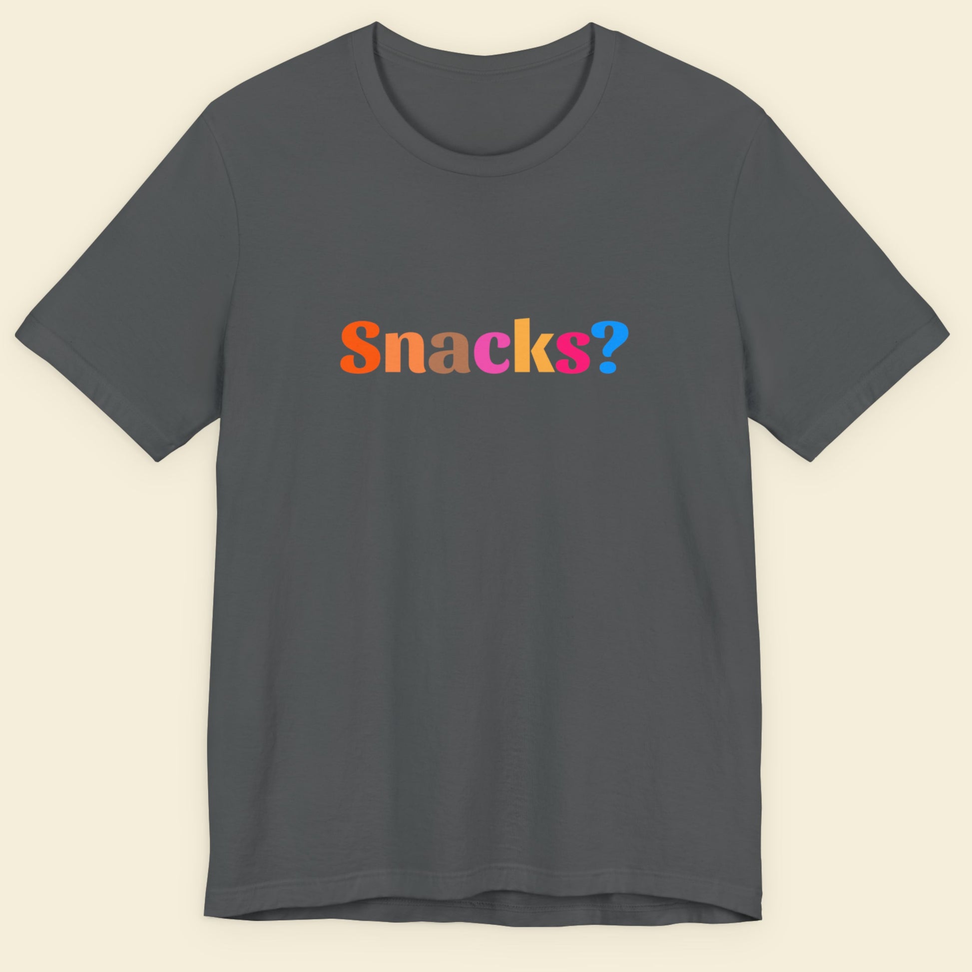 Gray t-shirt with 'Snacks?' text in multicolor on a beige background.