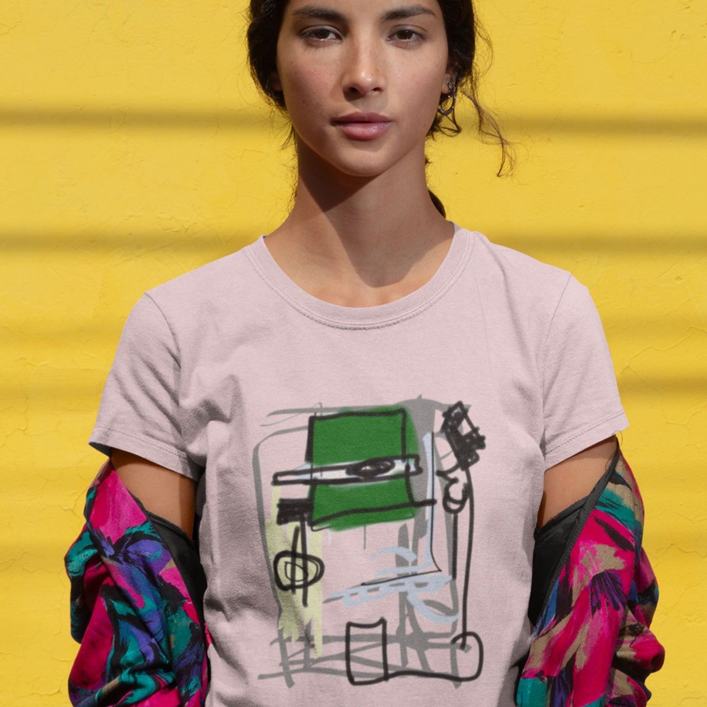 Person wearing a t-shirt with a graphic design against a yellow background.