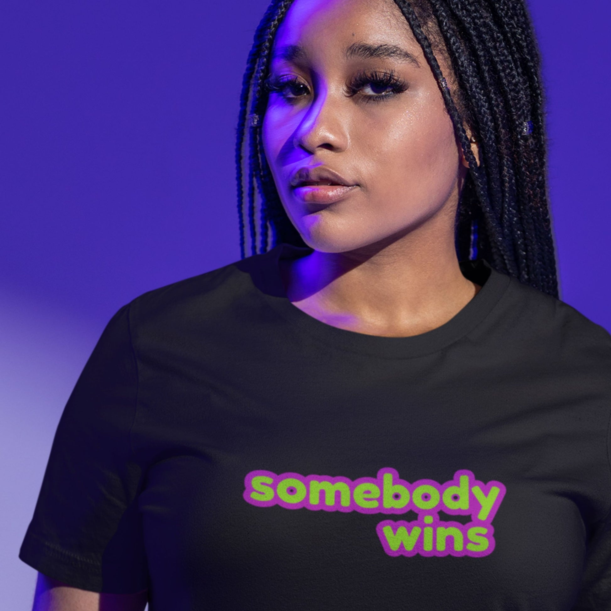 Serious woman wearing a black t-shirt with multicolored 'somebody wins' text on a purple umbre background.