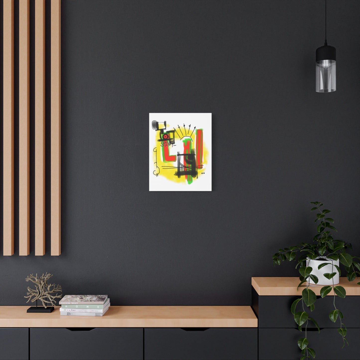 Abstract artwork on a black wall with a wooden shelf and plant in the foreground.