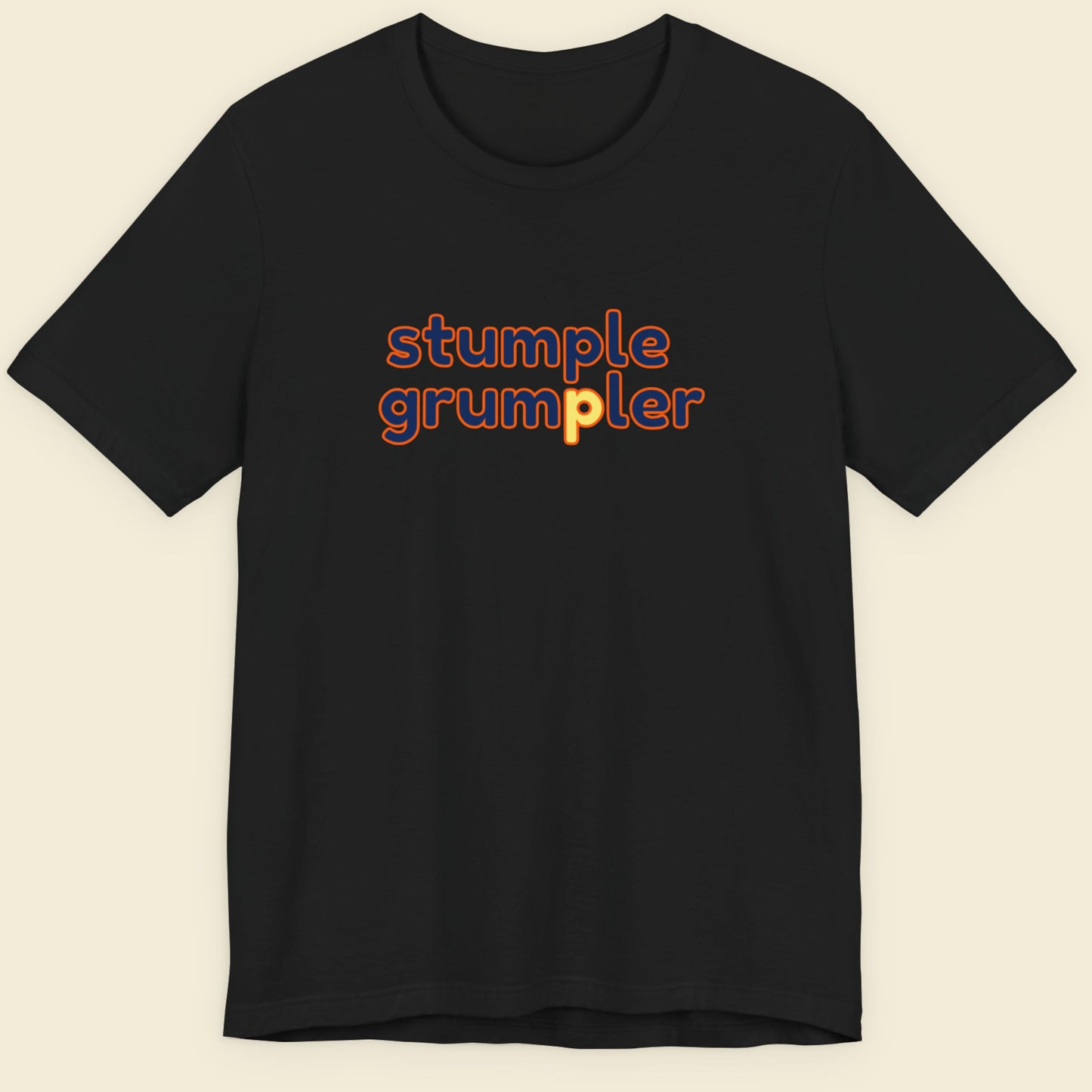 Black t-shirt with multicolored 'stumple grumpler' text on a beige background.