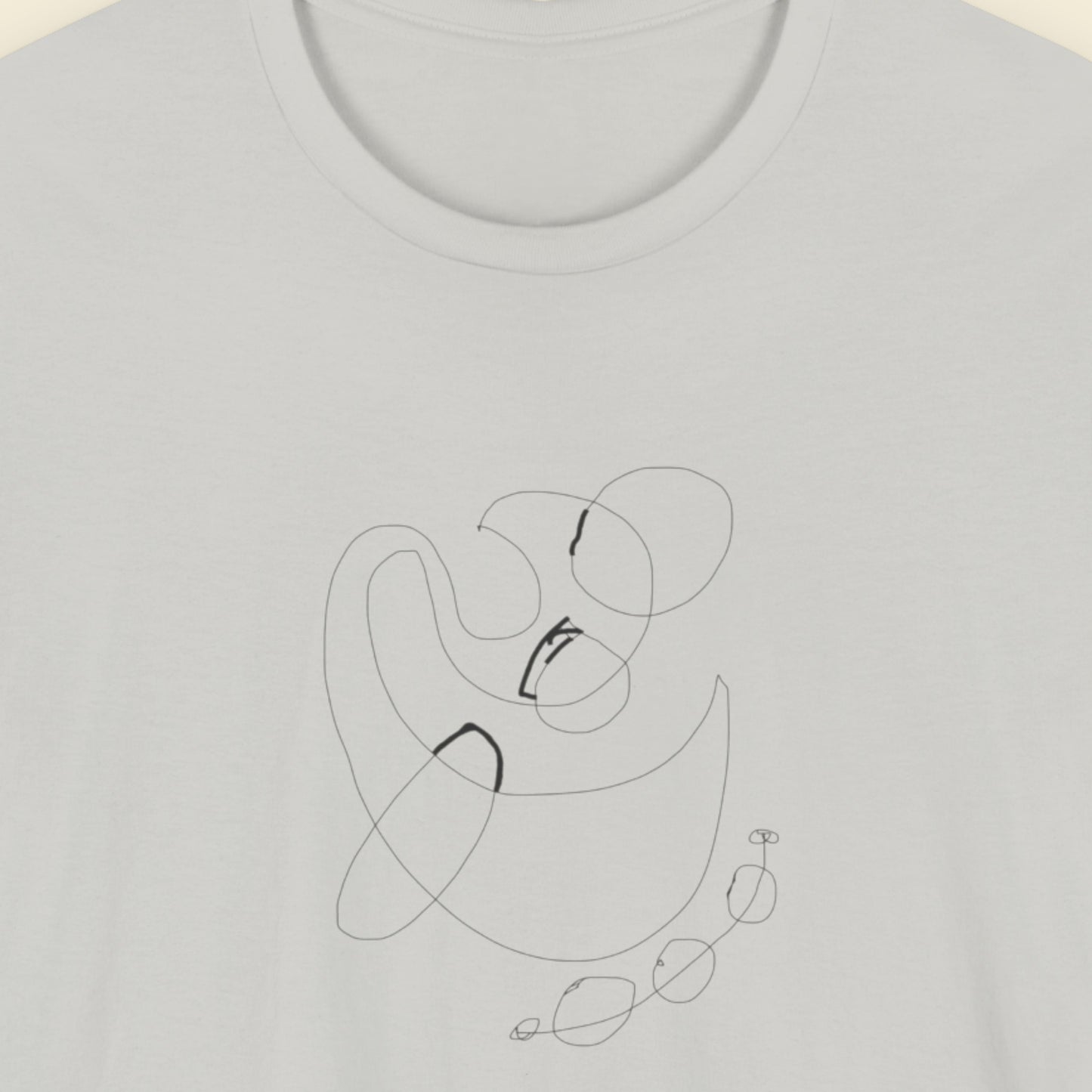 Grey shirt with an abstract black line drawing on a light beige background.