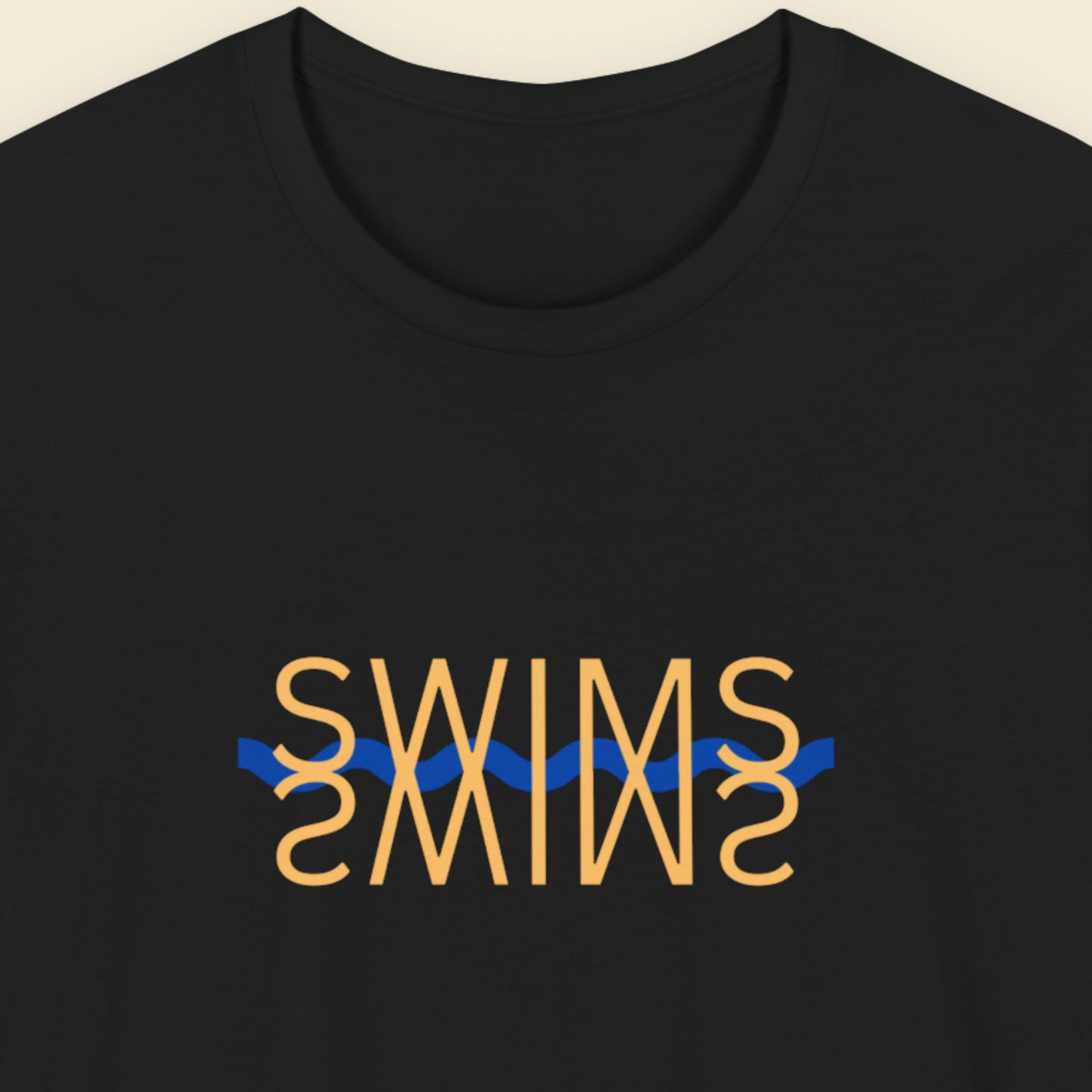 Black t-shirt with humorous colorful text on a beige background.