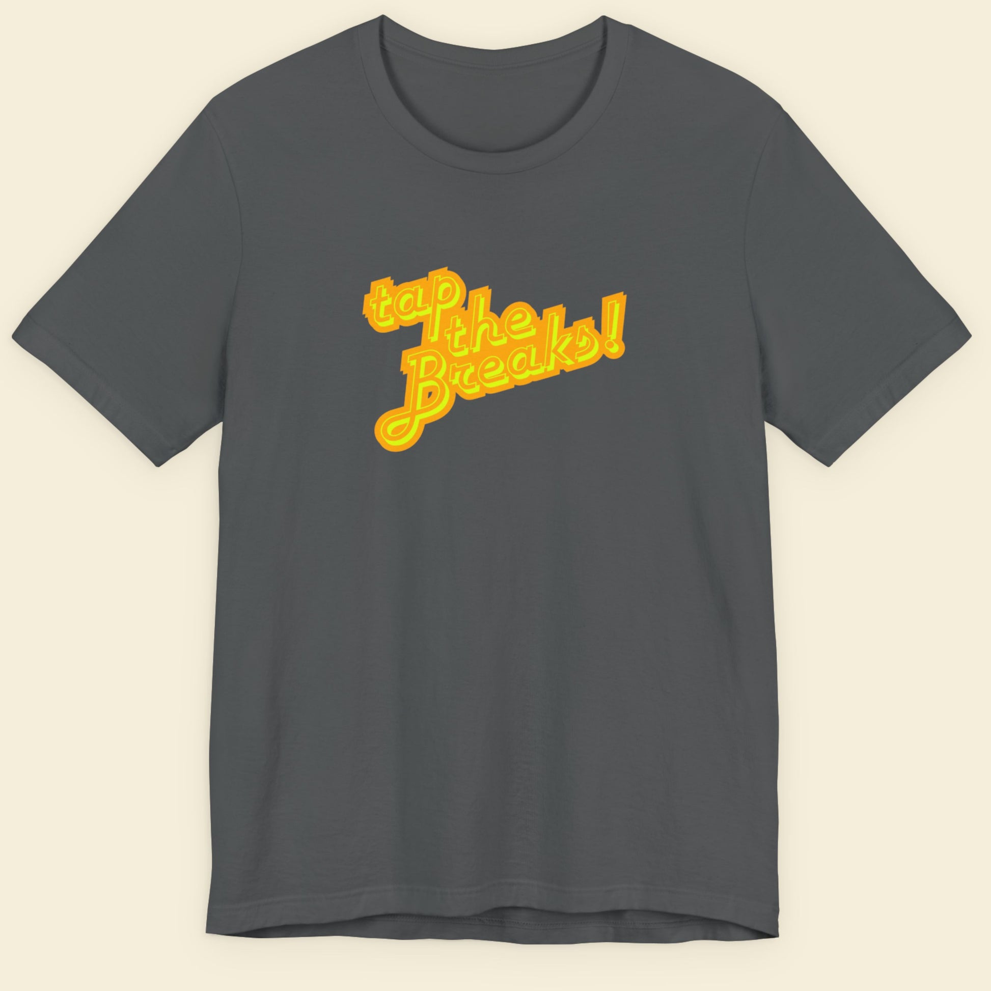 Grey t-shirt with humorous colorful text on a beige background.