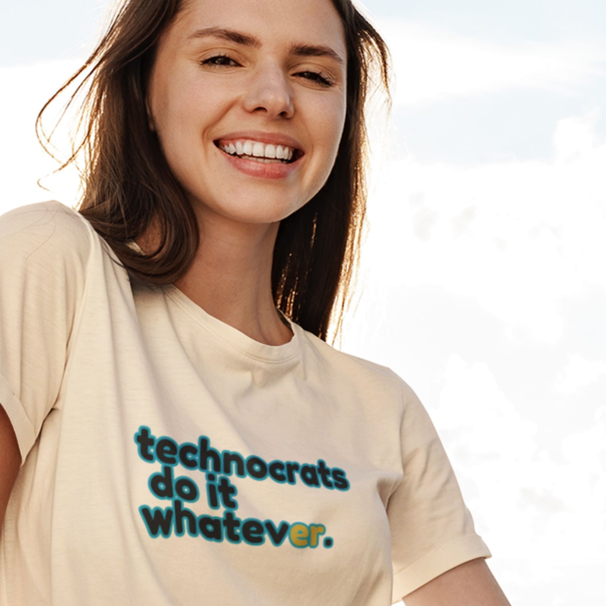 Woman wearing a t-shirt with text 'technocrats do it whatever' against a light background