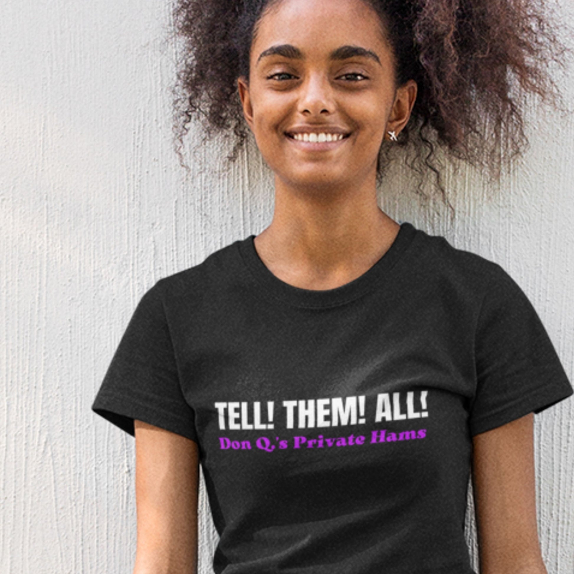 Person wearing a black t-shirt with text, standing against a light background.