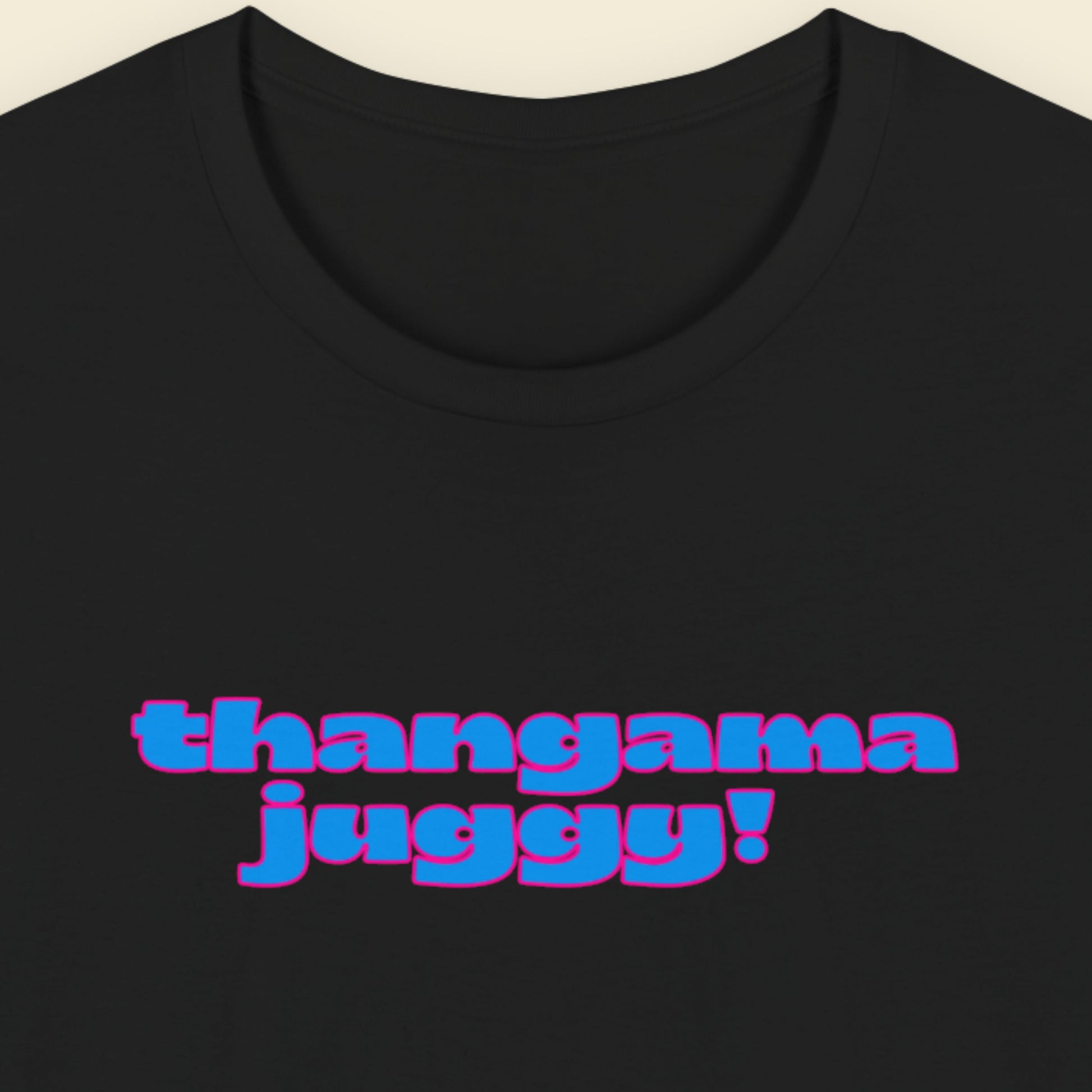 Black t-shirt with humorous colorful text on a beige background.