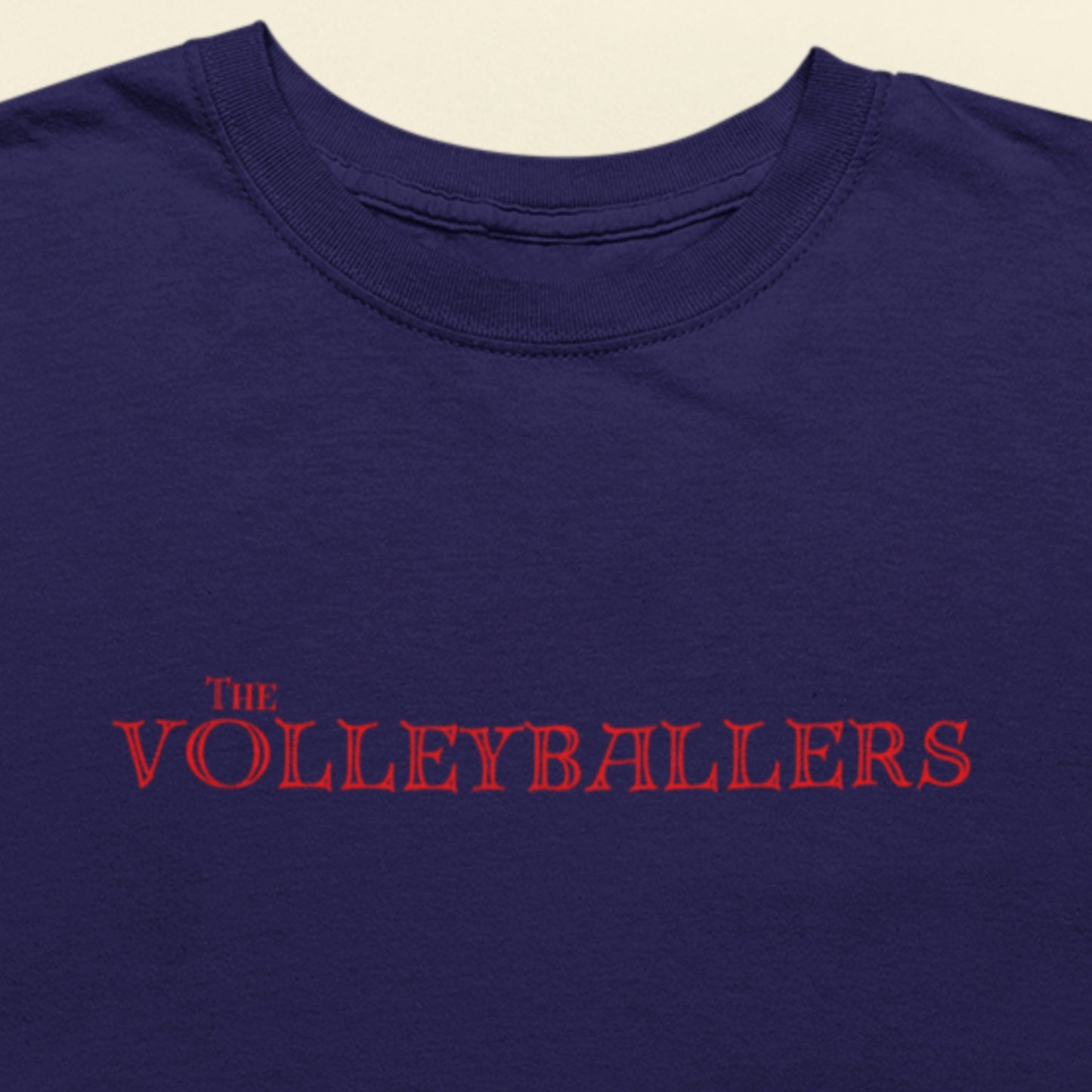 Navy blue shirt with 'The Volleyballers' text in red on a beige background