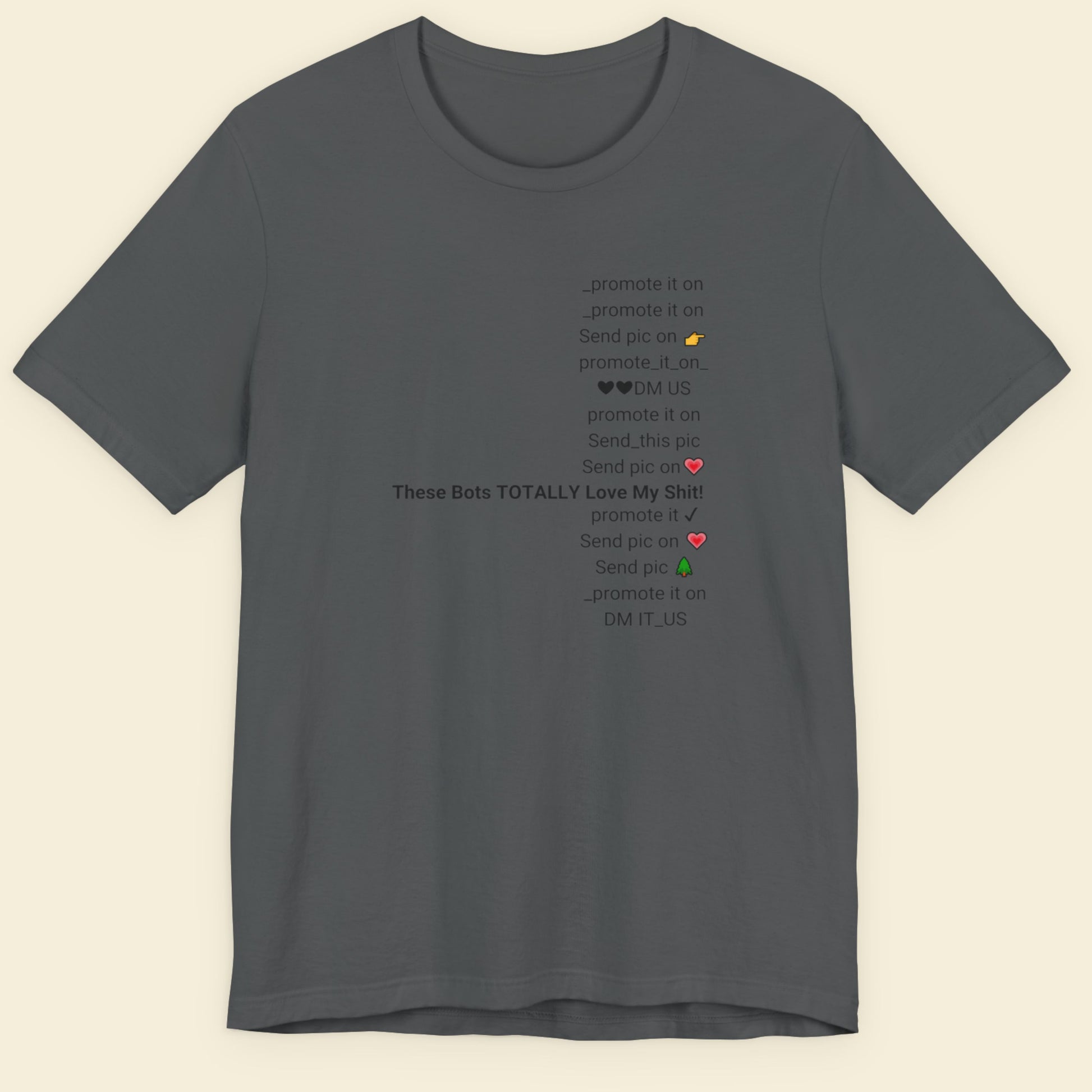Gray t-shirt with text and emojis on a beige background.