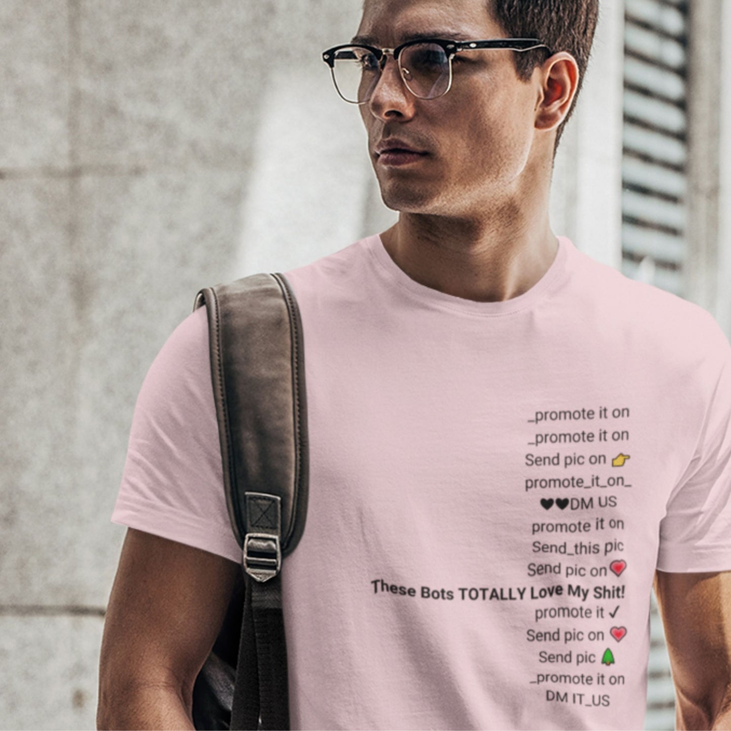 Man wearing a pink t-shirt with text design, standing outdoors.