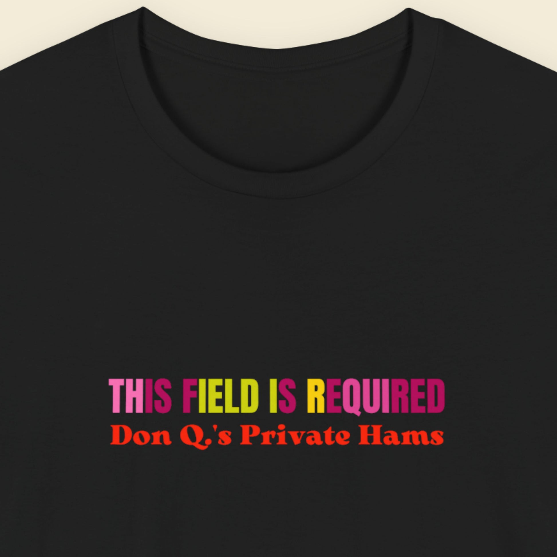 Black t-shirt with nonsensical, multicolored text on a beige background.