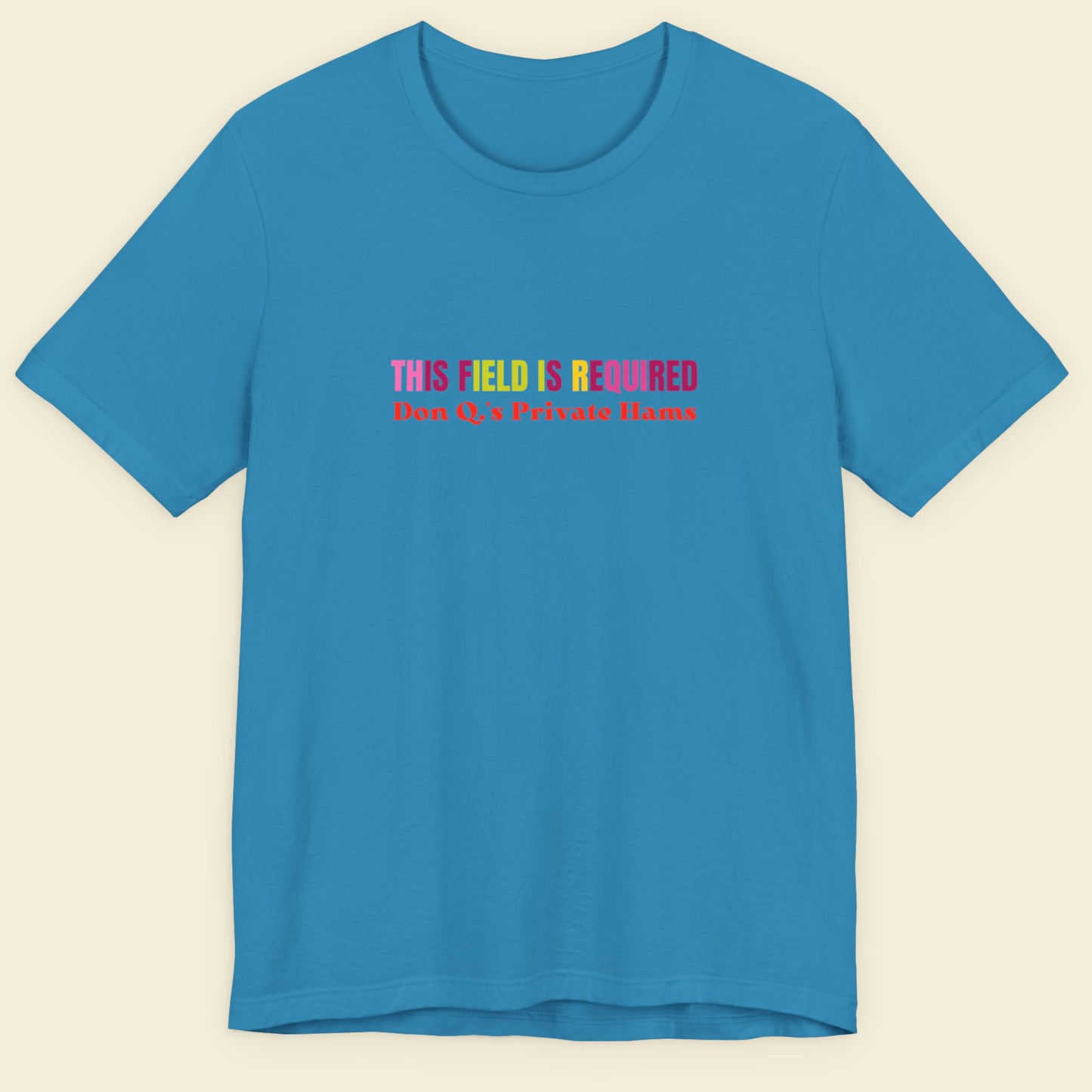 Aqua blue t-shirt with nonsensical, multicolored text on a beige background.