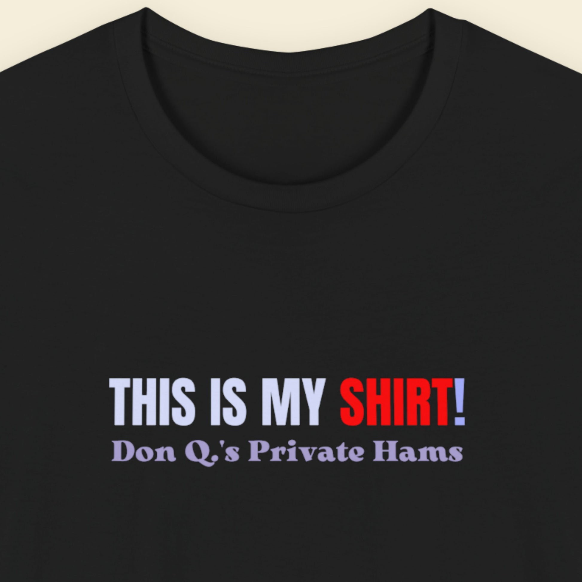 Black t-shirt with multicolored 'THIS IS MY SHIRT!' text on a beige background.