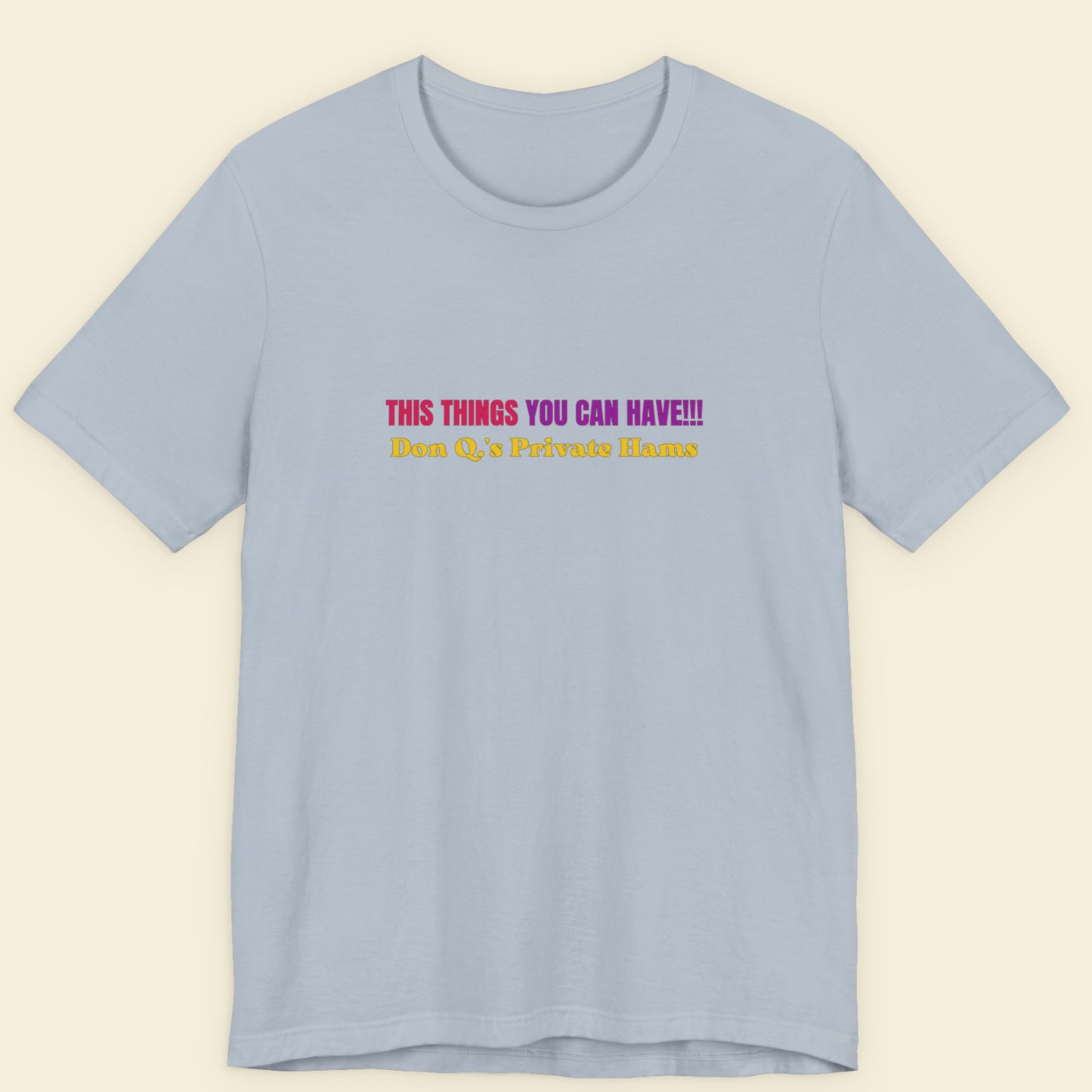Light blue t-shirt with colorful text on a beige background