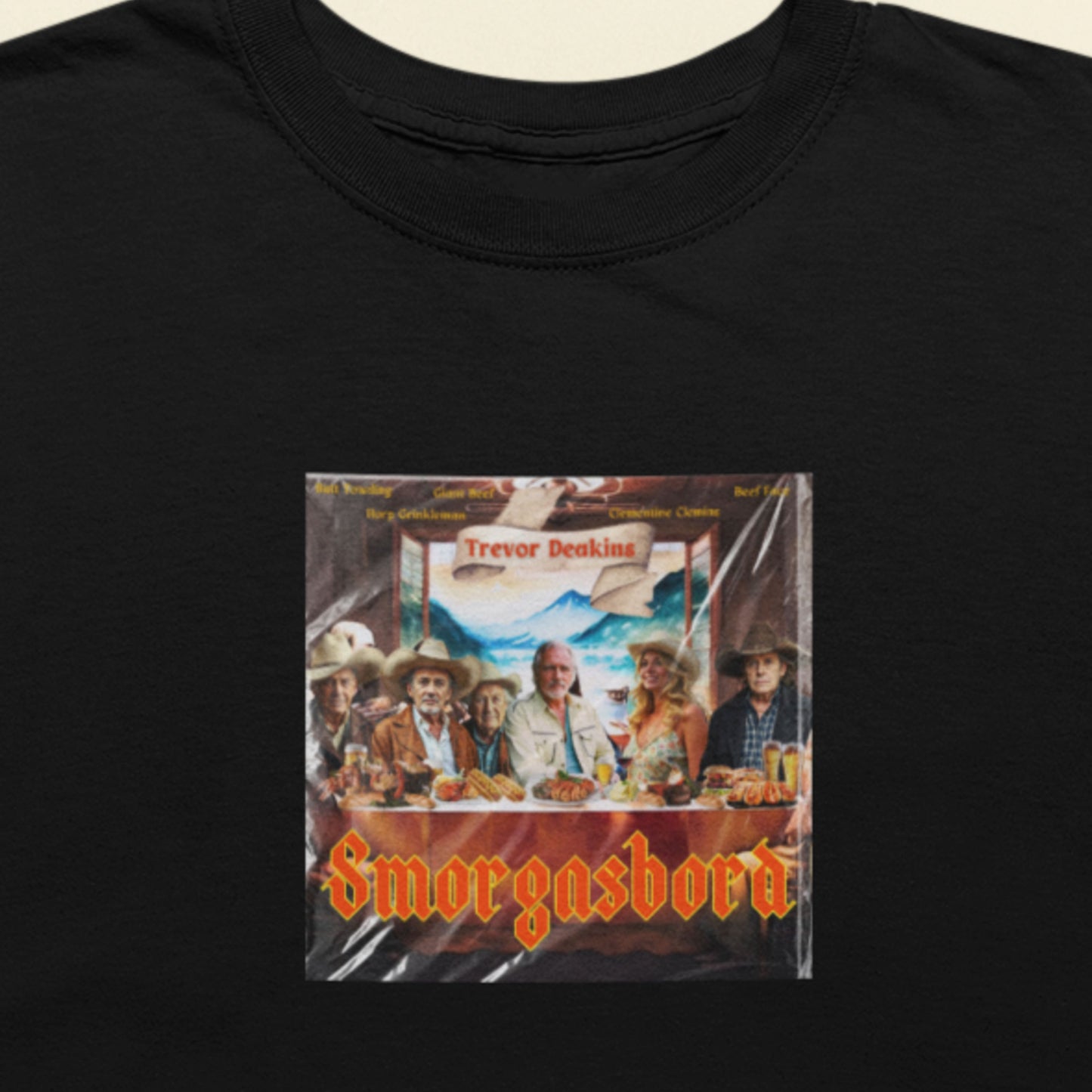 Black t-shirt with a graphic of 'Smorgasbord' featuring people around a table.