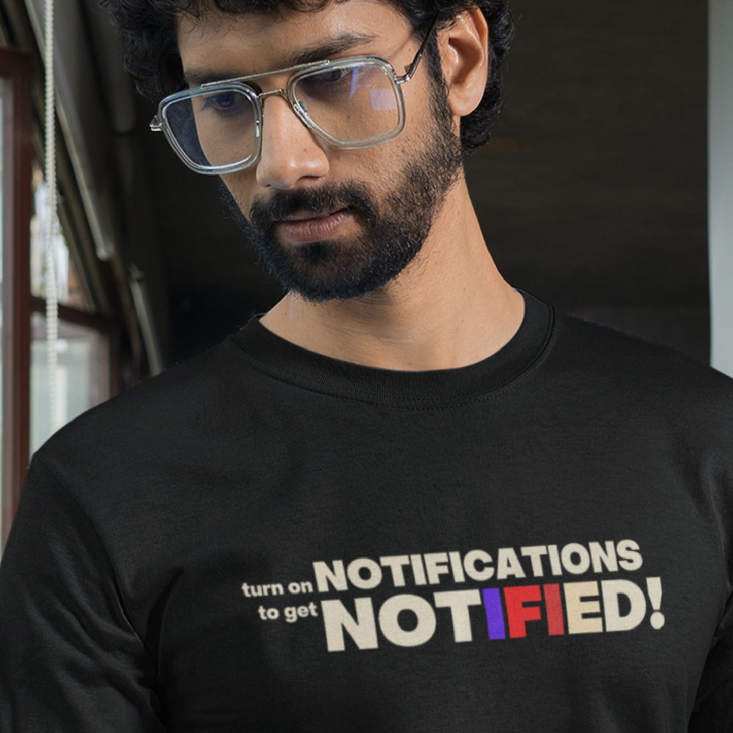 Man wearing a black t-shirt with colorful text design.