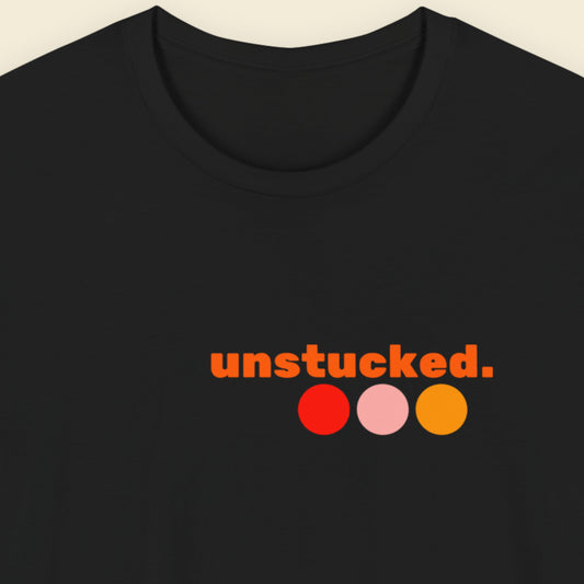 Black t-shirt with humorous colorful text and dots on a beige background.