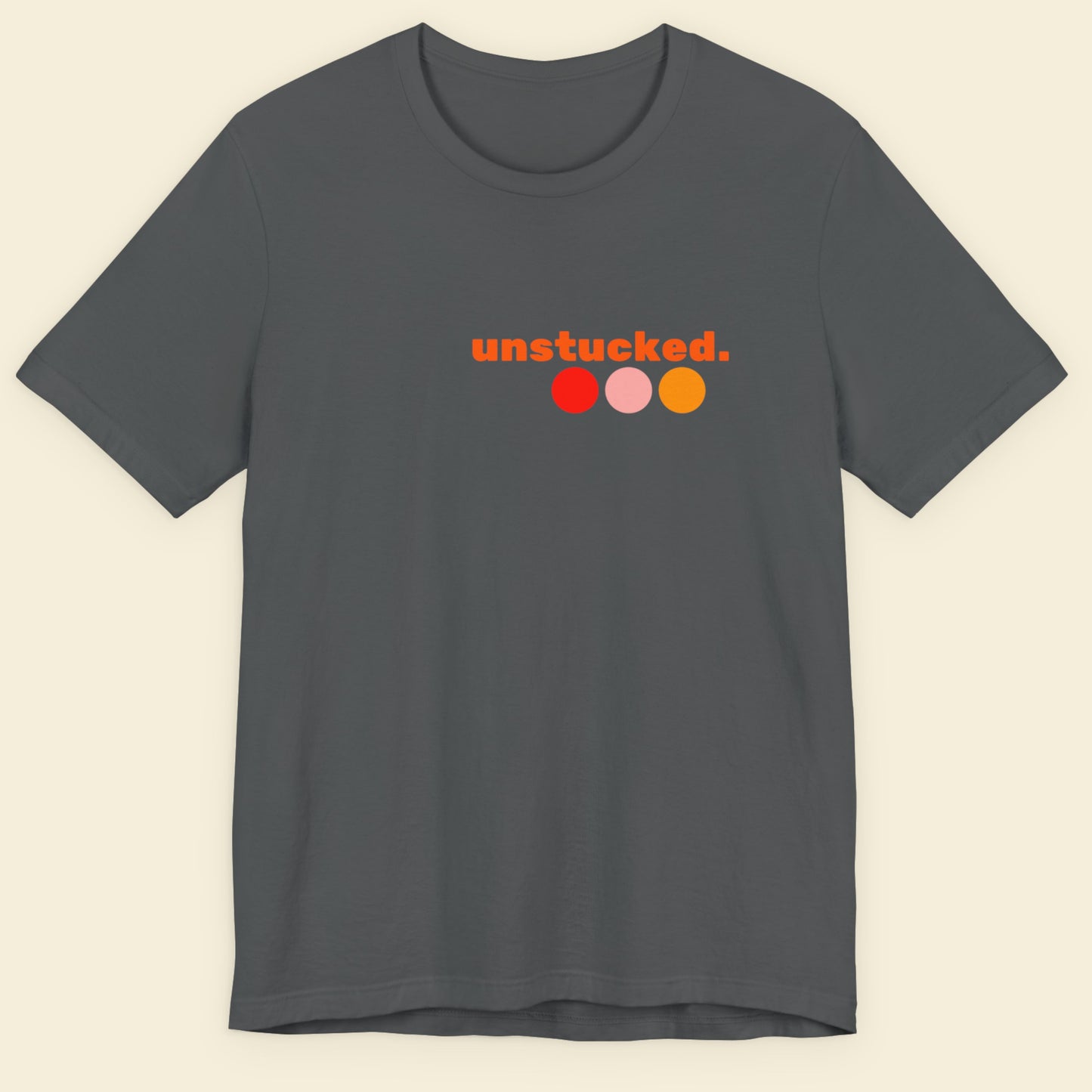 Gray t-shirt with 'unstucked.' logo on a beige background.