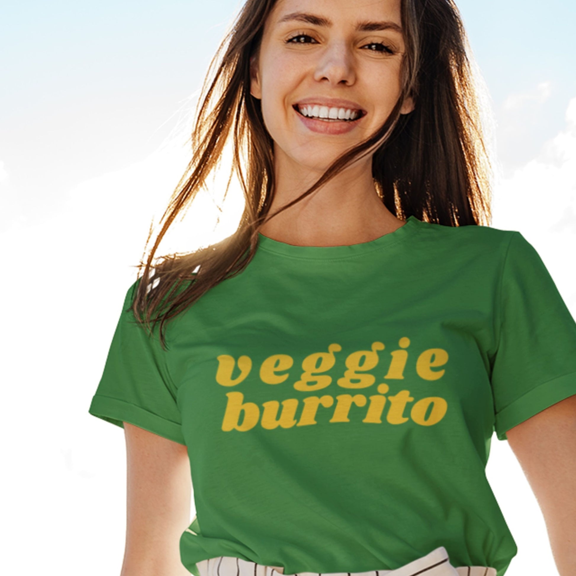 Heather green shirt with funky 70's style font saying 'veggie burrito' worn by model