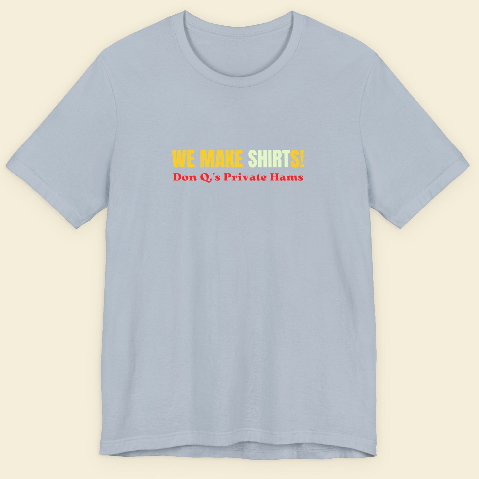 Light blue t-shirt with multicolored 'we make shirts!' text on a beige background.