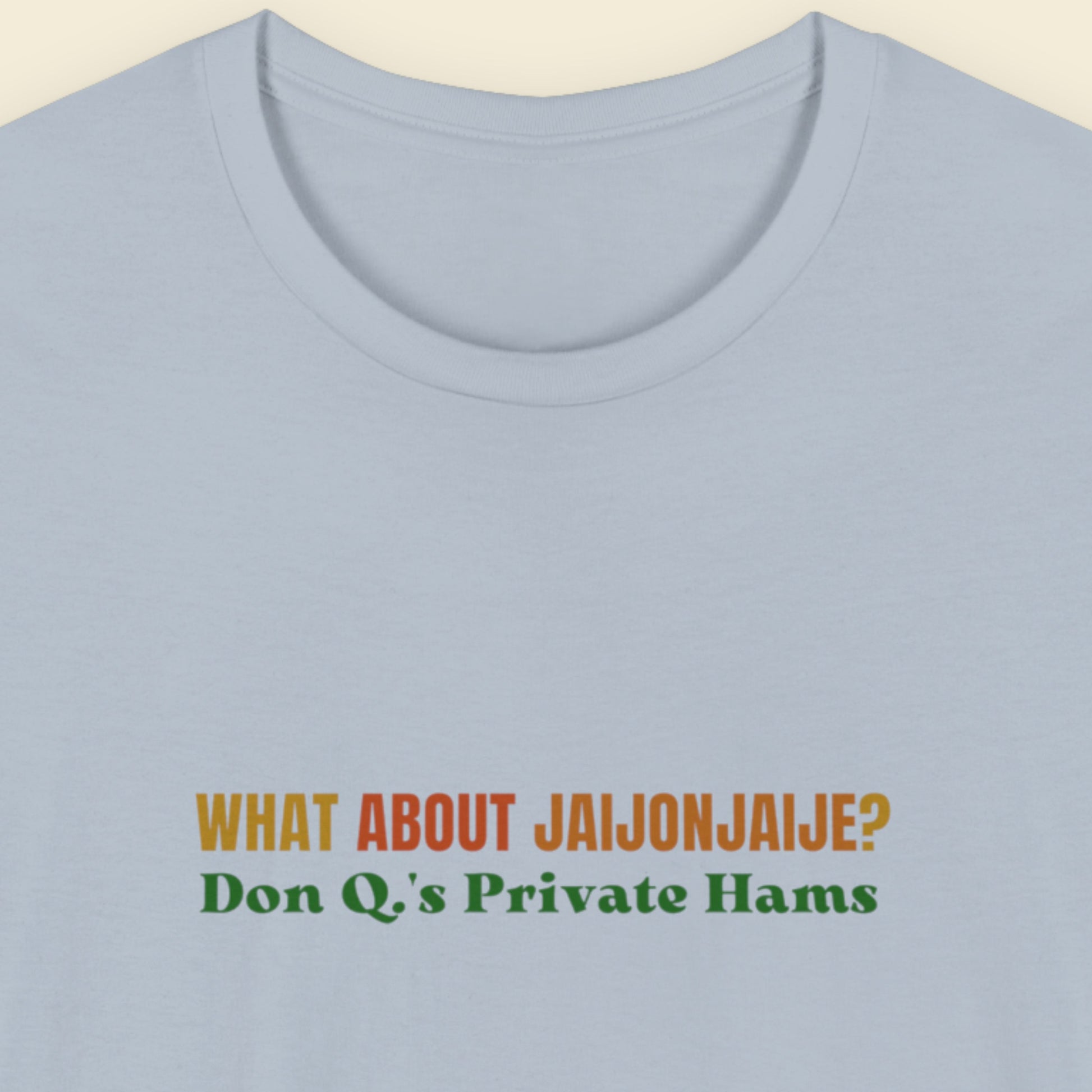 Light blue t-shirt with humorous colorful text on a beige background.