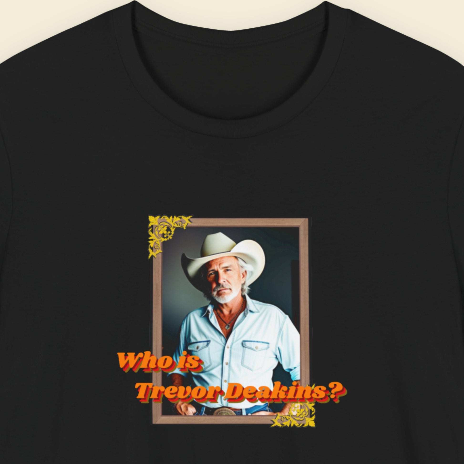 Black t-shirt with a graphic of a man in a cowboy hat and text 'Who is Trevor Deakin?' on a beige background
