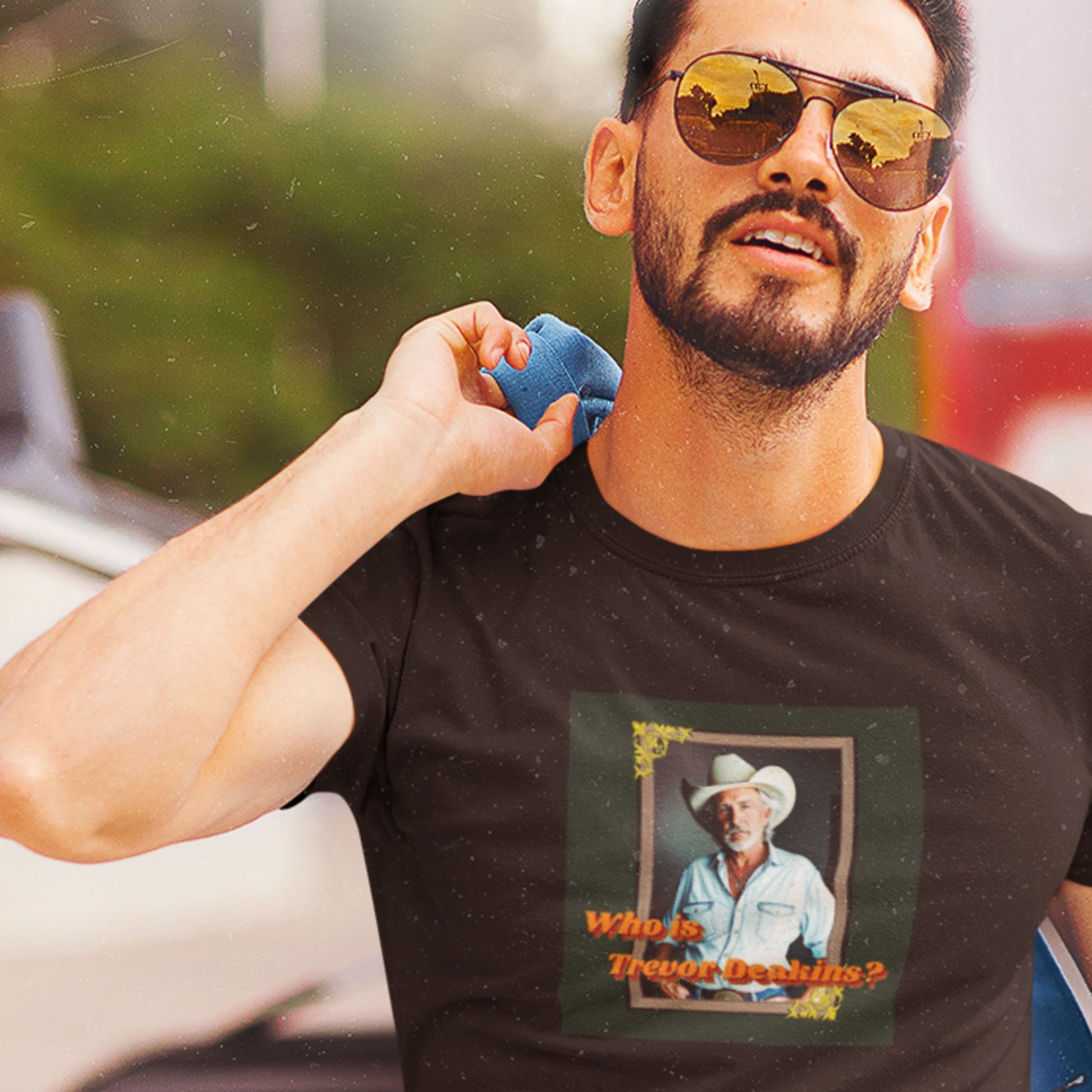 Man wearing sunglasses and a black t-shirt with a graphic design outdoors