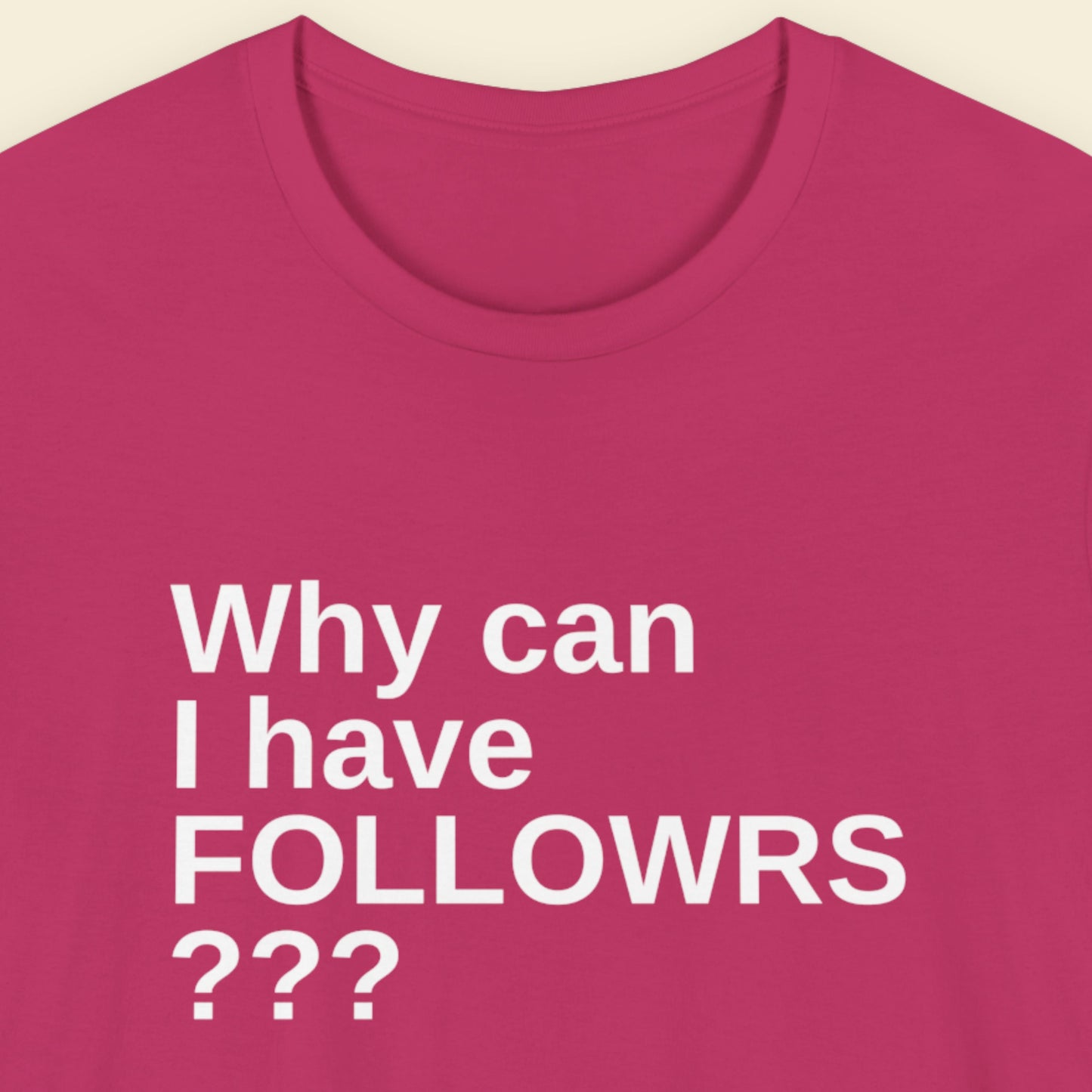 Pink t-shirt with white text 'Why can I have FOLLOWRS ???' on a beige background.