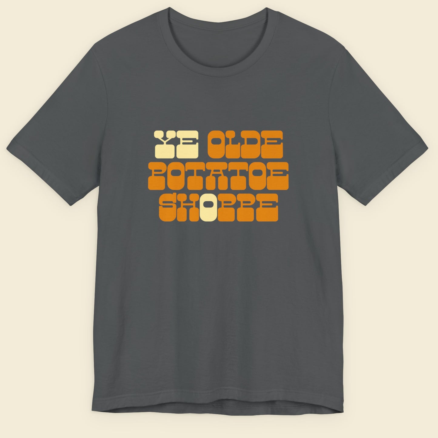 Gray t-shirt with colorful text design on a beige background.