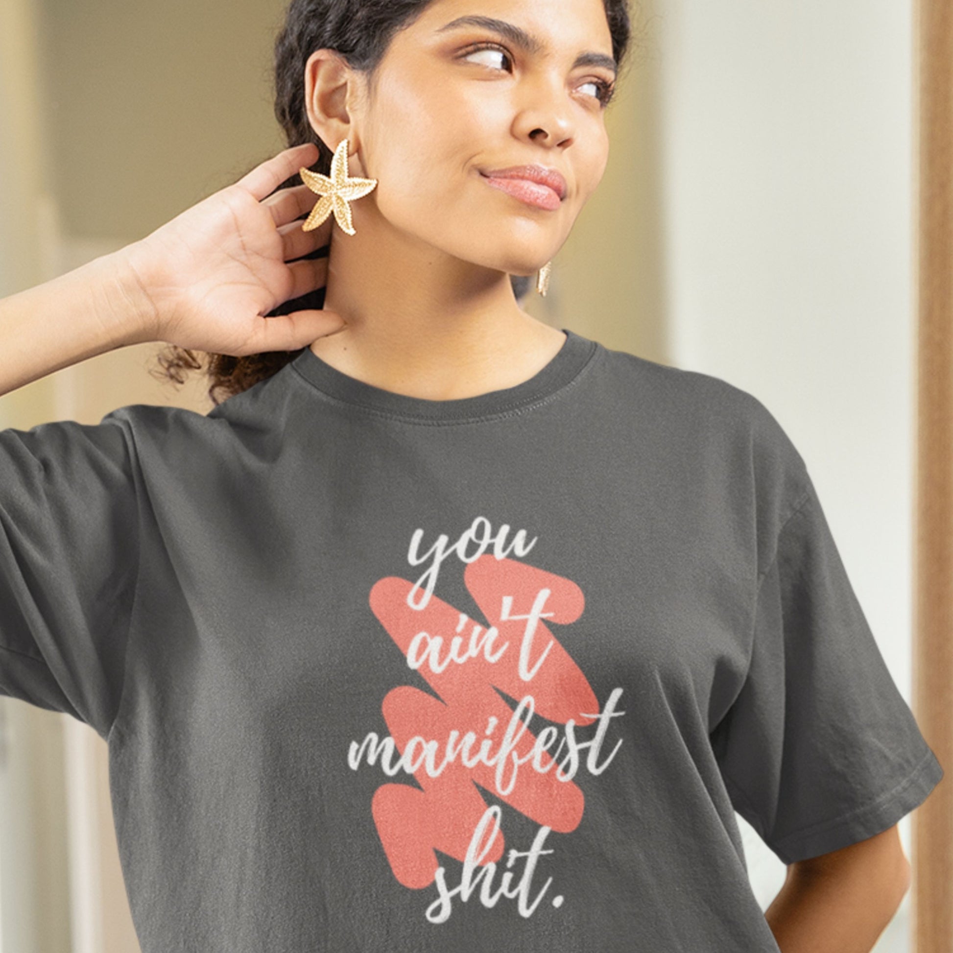 Person wearing a gray t-shirt with a graphic and text.