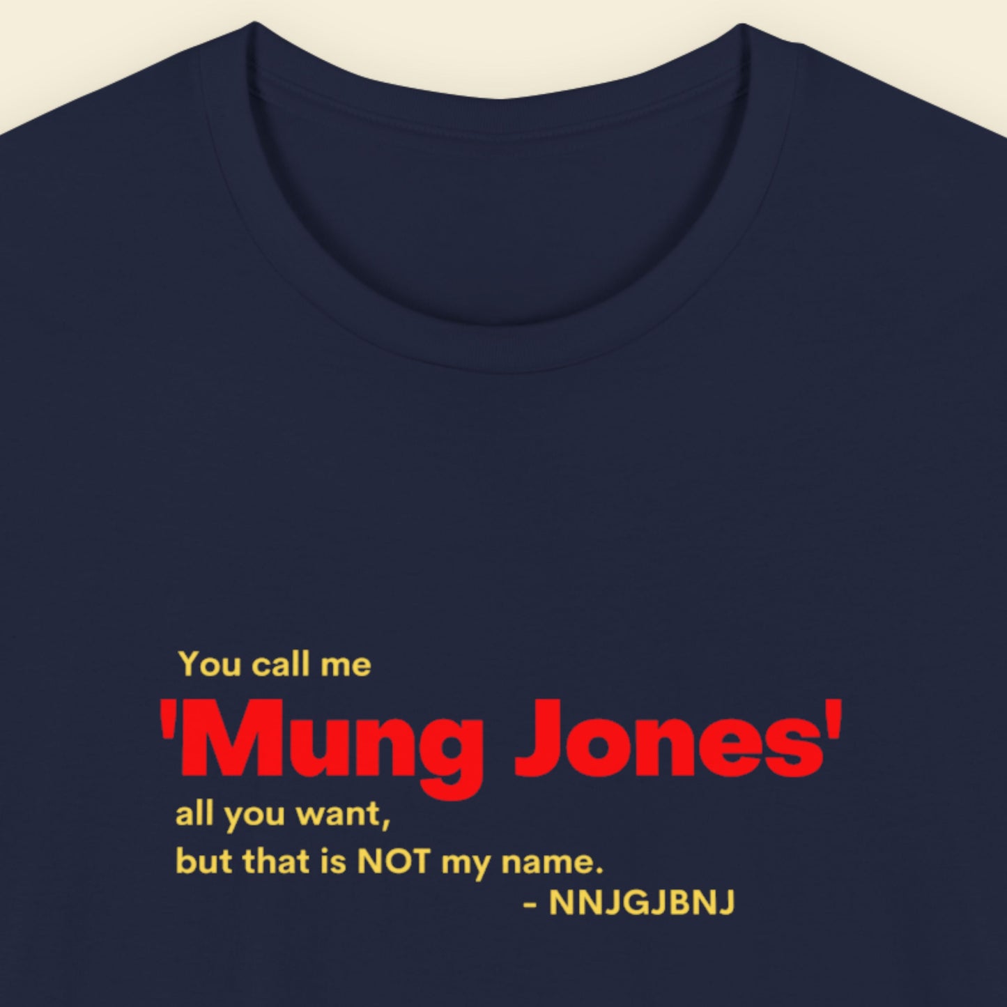 Navy blue t-shirt with red and yellow text on a beige background.