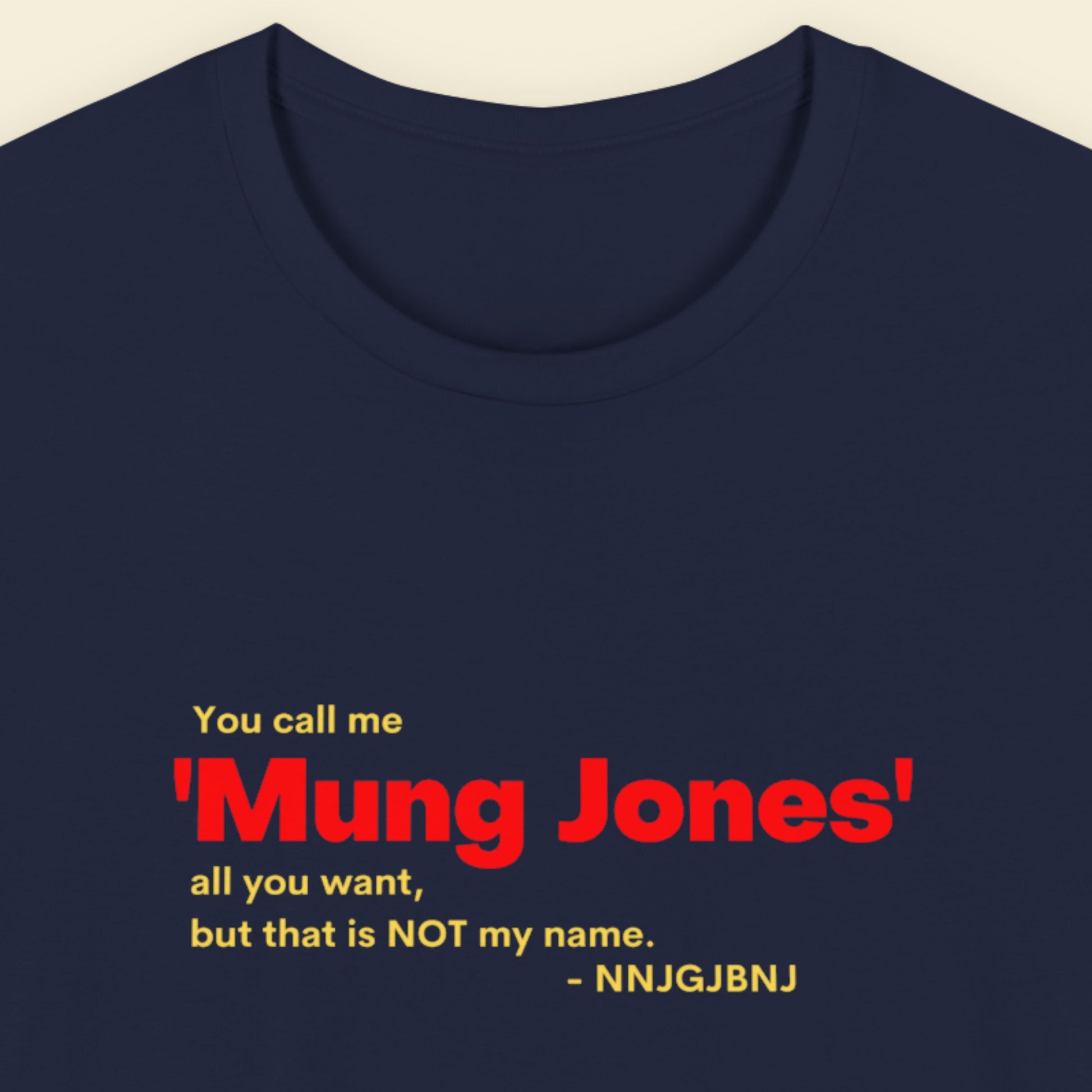 Navy blue t-shirt with red and yellow text on a beige background.