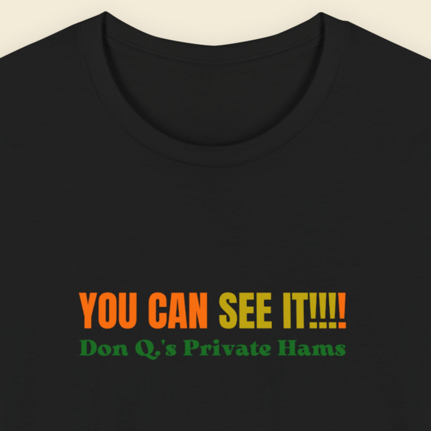 Black t-shirt with multicolored 'you can see it!!!!' text on a beige background.
