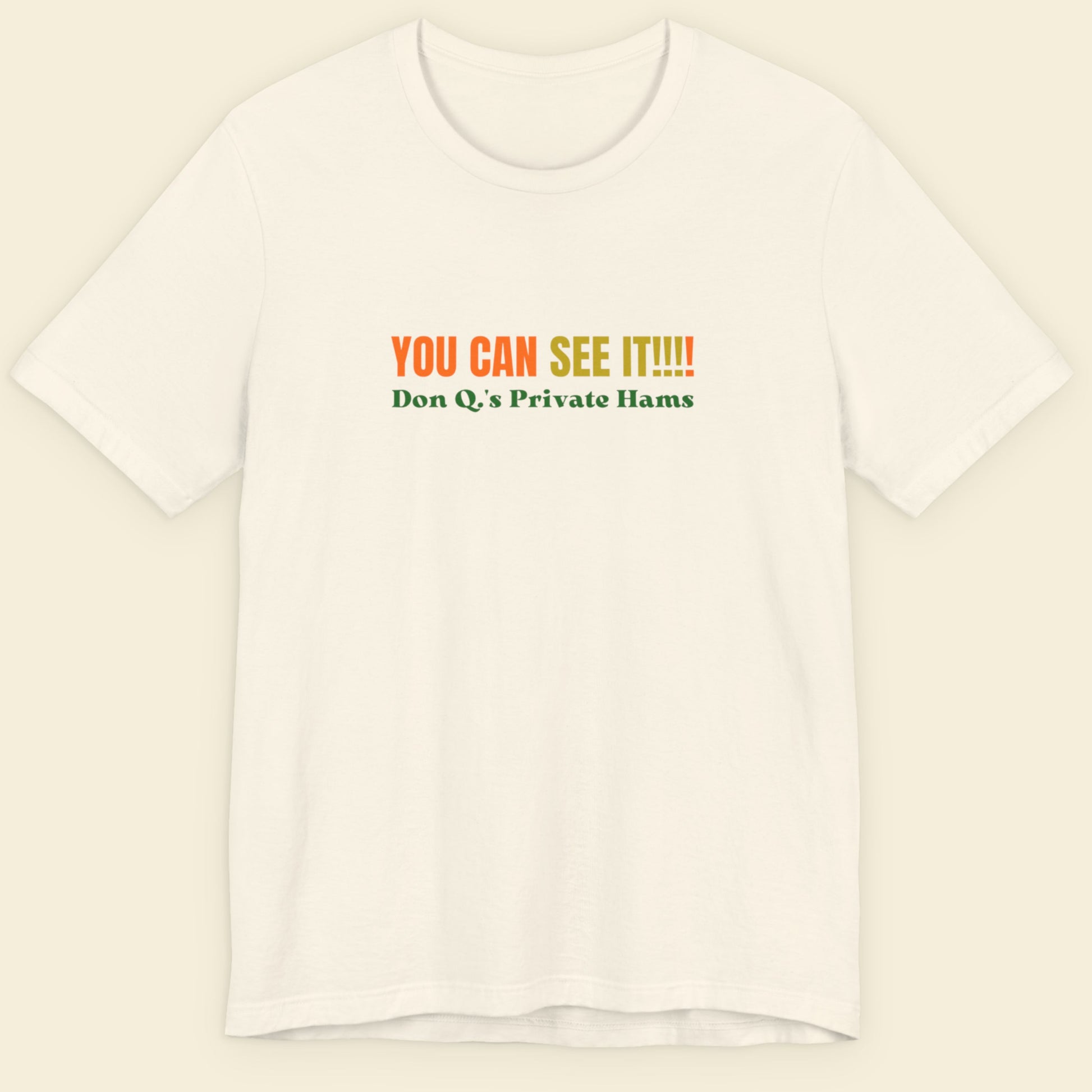 Off-white t-shirt with multicolored 'you can see it!!!!' text on a beige background.