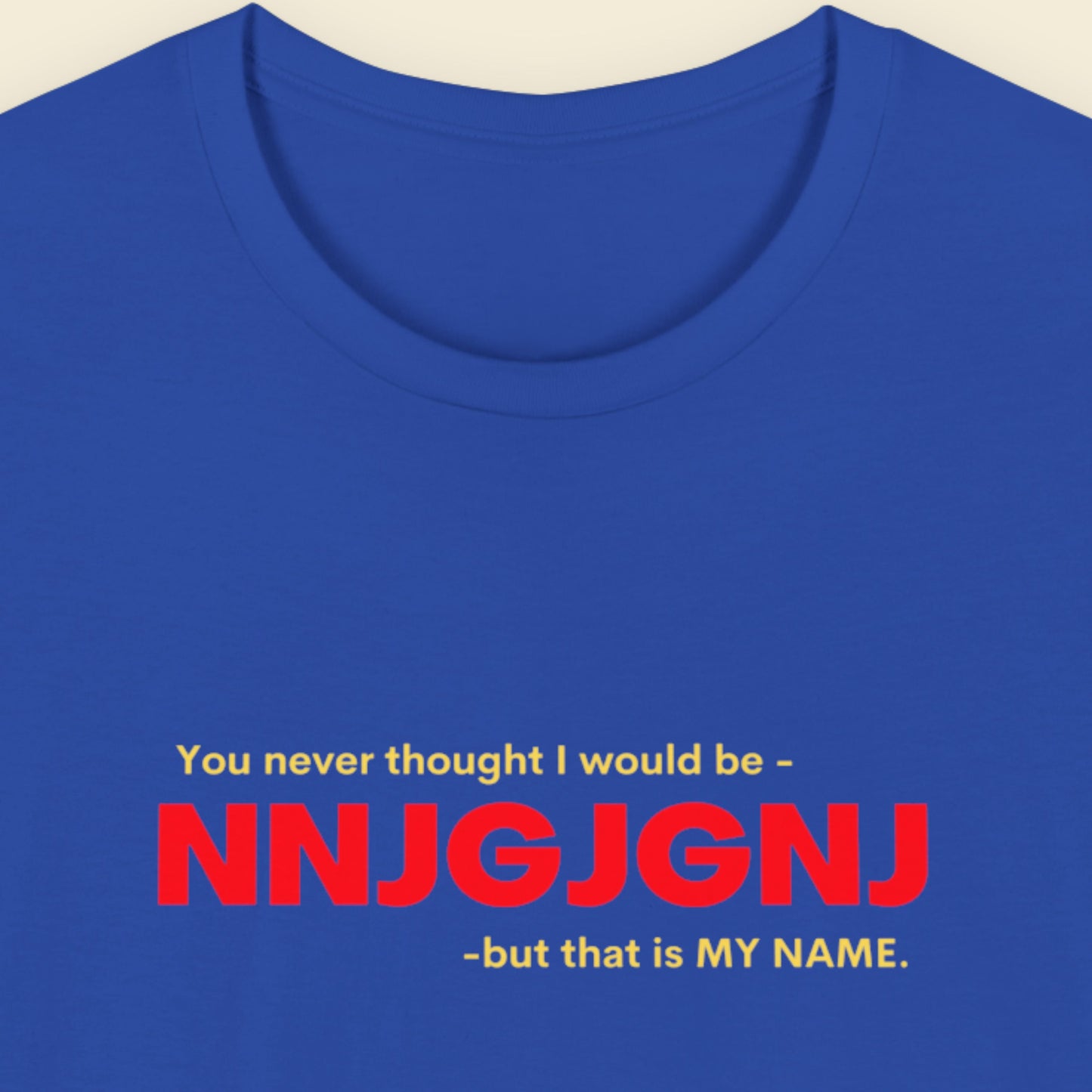 Blue t-shirt with red and yellow text on a beige background.