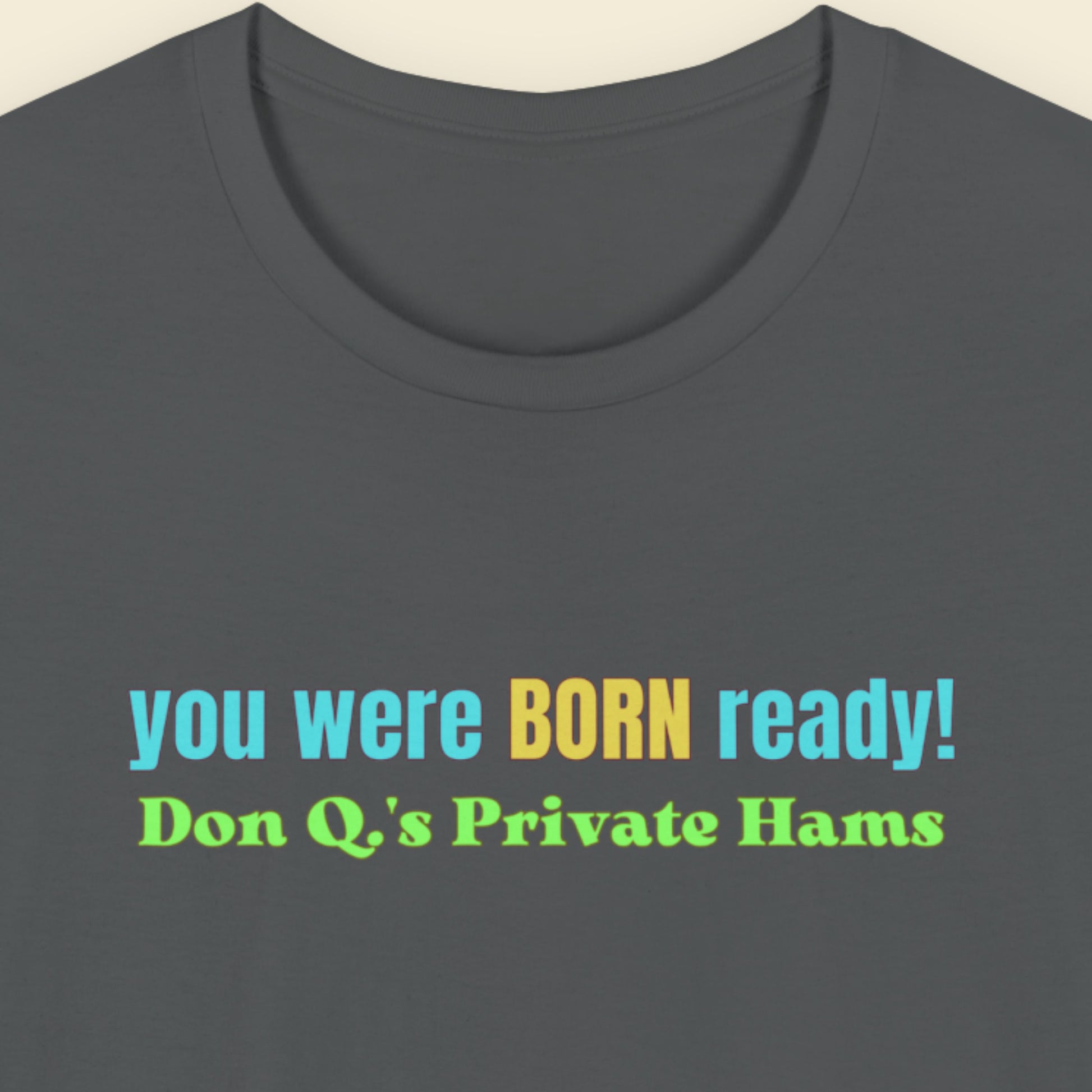 Gray t-shirt with colorful text on a beige background.