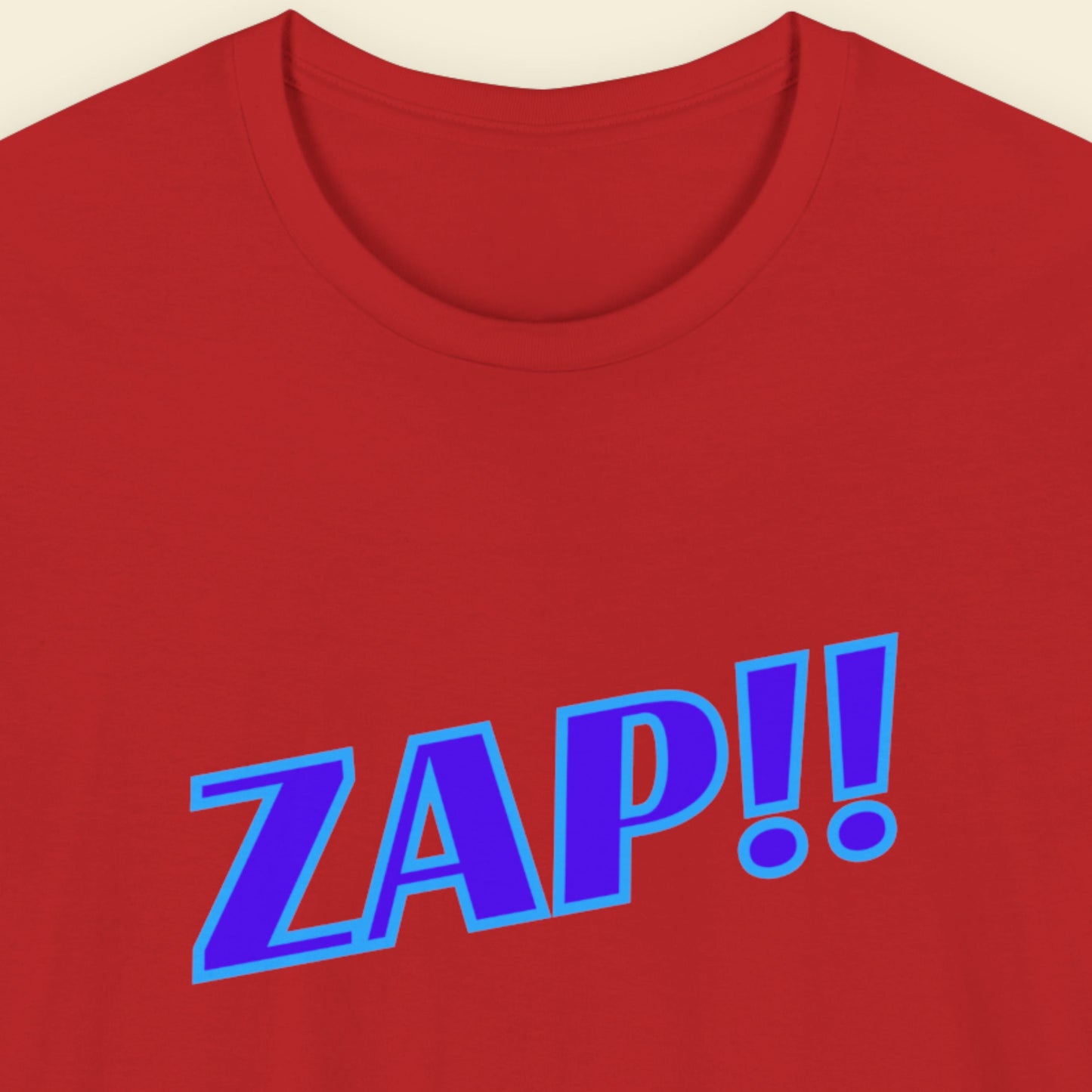 Red t-shirt with blue 'ZAP!!' text on a beige background.