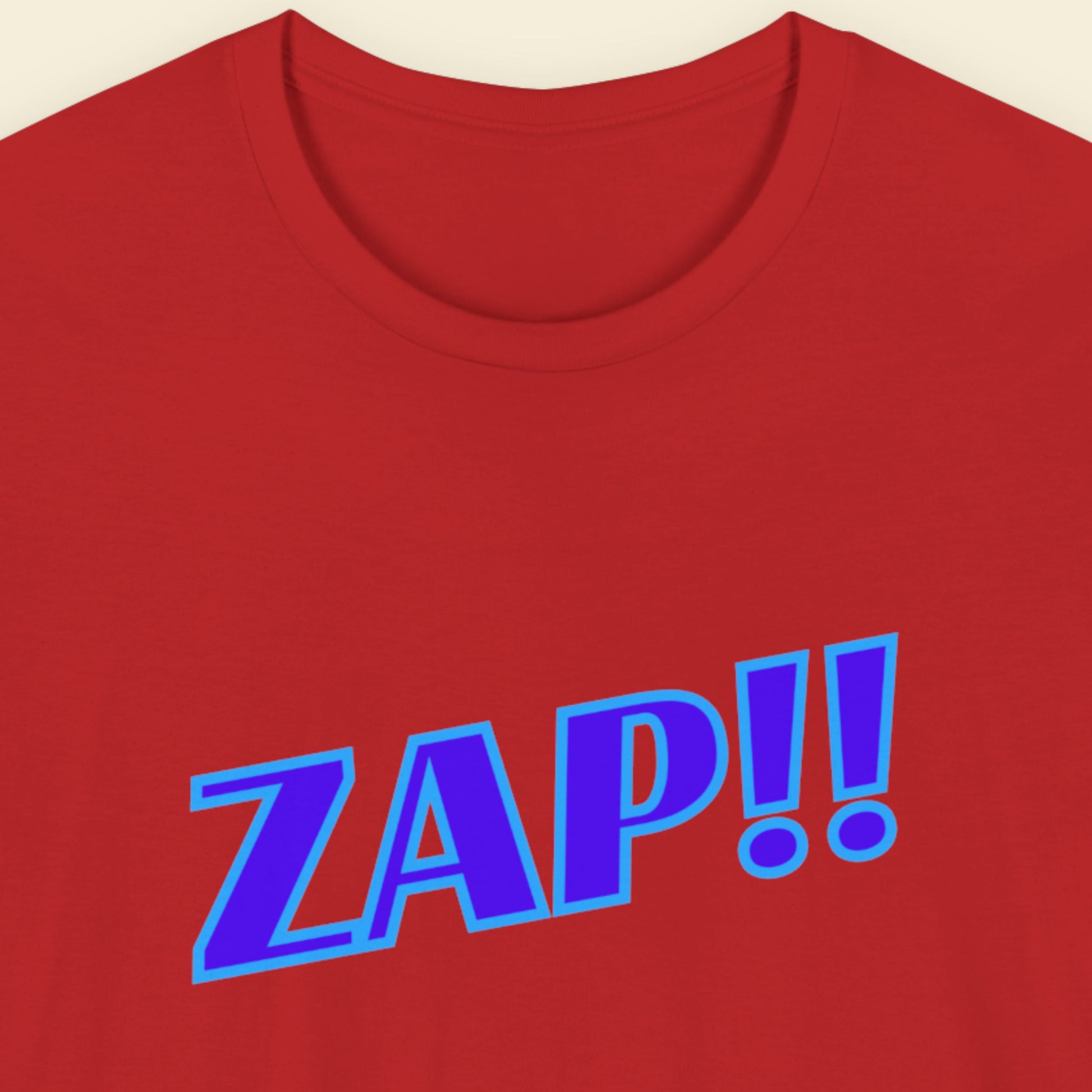 Red t-shirt with blue 'ZAP!!' text on a beige background.