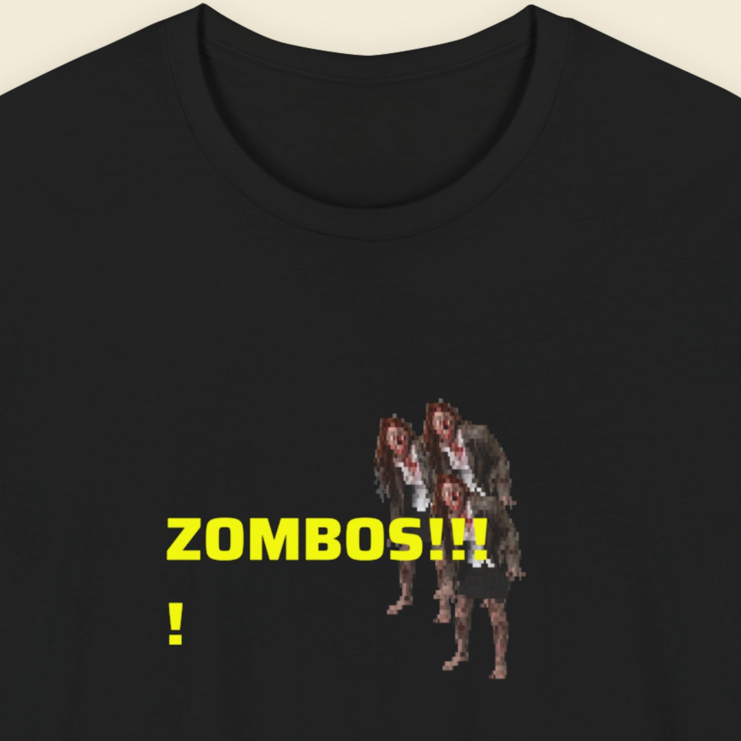 Black t-shirt with pixelated zombie graphic and 'ZOMBOS!!!' text on a beige background.
